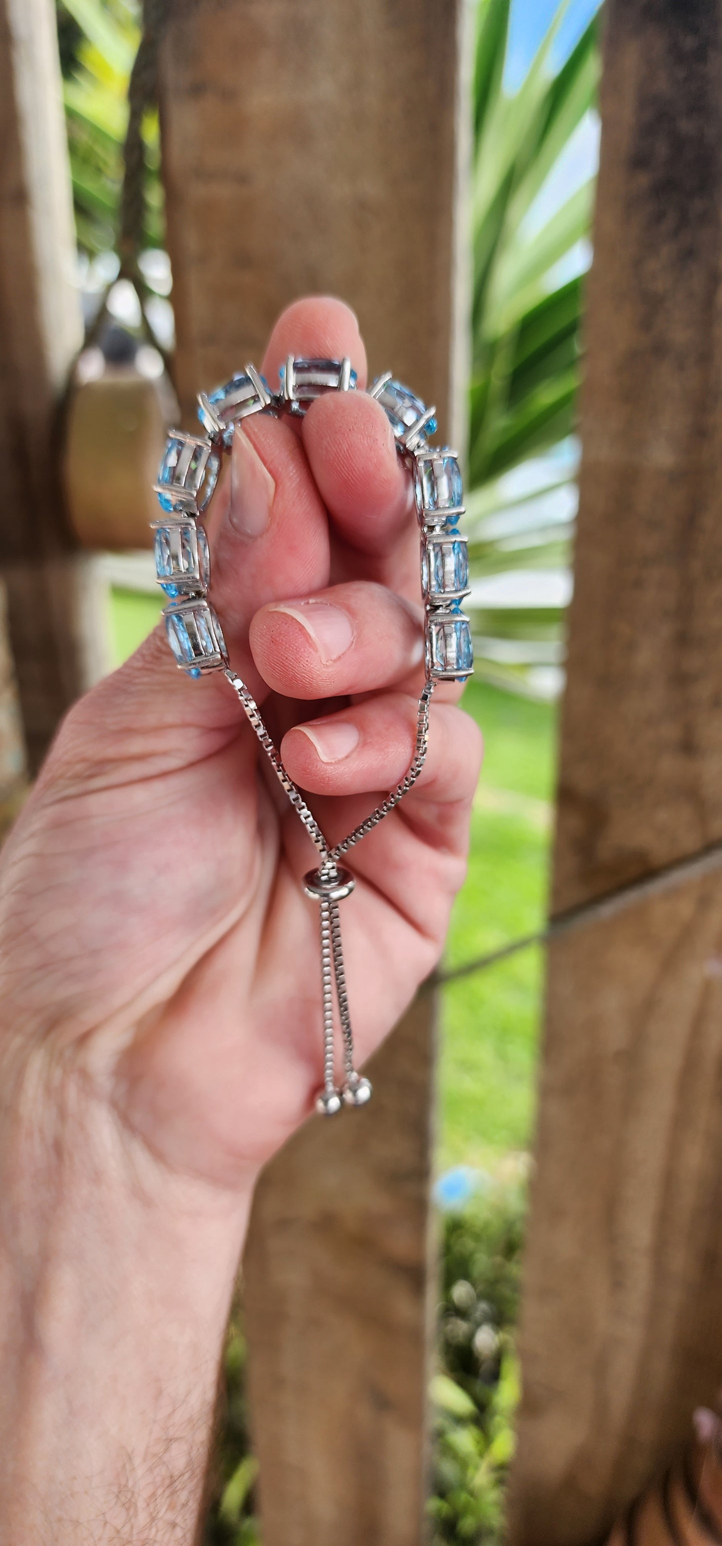 This gorgeous and STATEMENT Tennis style bracelet is crafted in Sterling Silver and features 9x large sized Oval Faceted Cut Blue Topaz Gemstones, claw set and studded together in an Tennis style, to give it a bold and stylish look.