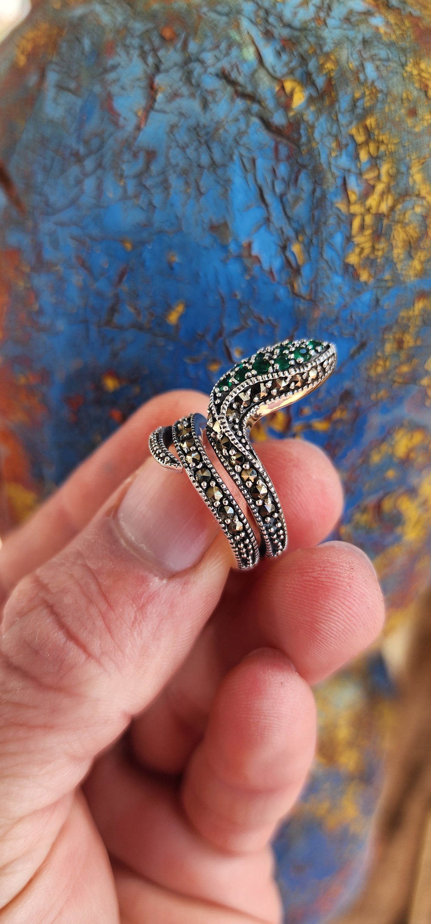 The elaborate Sterling Silver Serpent ring skillfully wraps itself around one's finger and heart.It has lovely scales composed of sparkly Marcasites, which shimmer beautifully in the light.