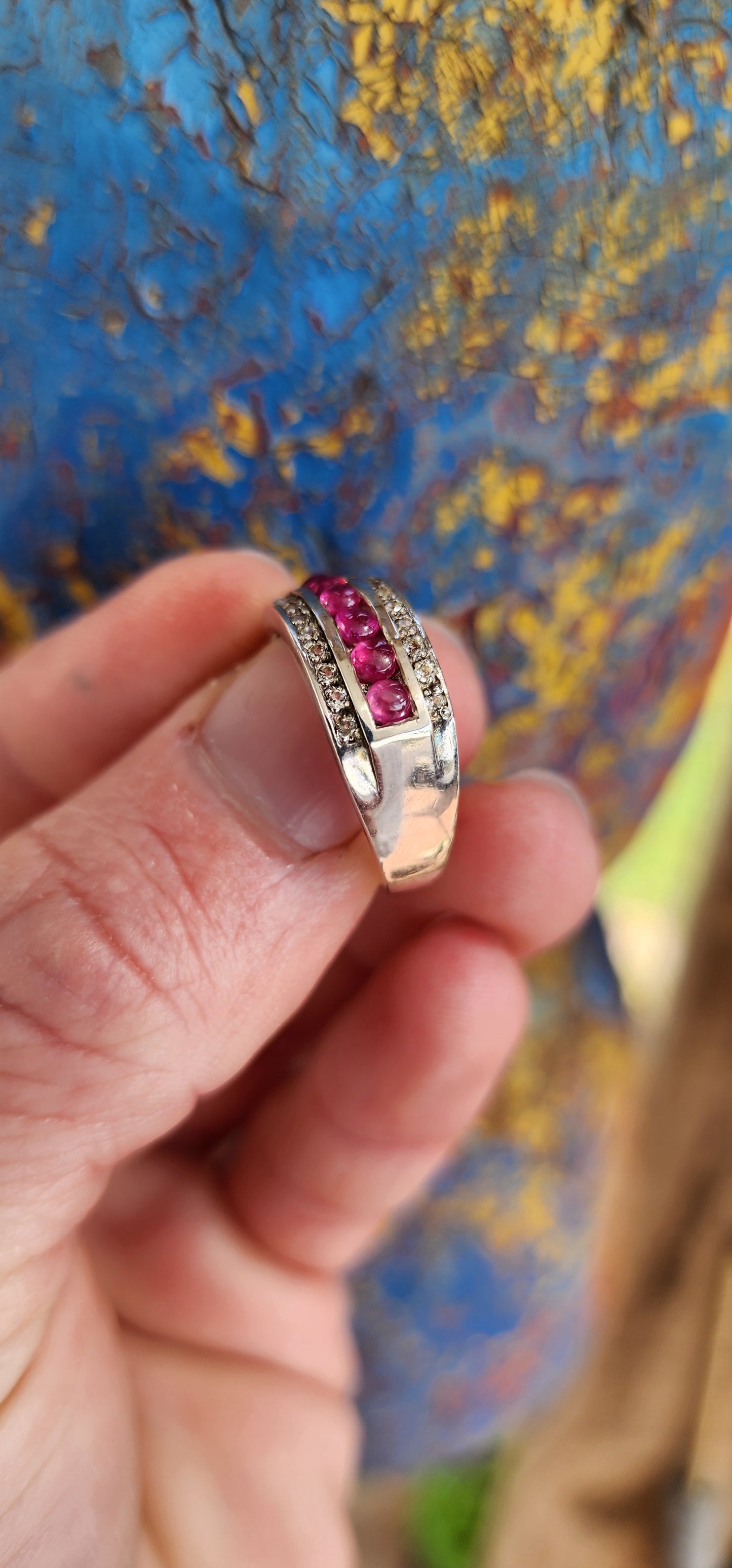 Classical 3 row Sterling Silver Art Deco style dress ring. Channel set with a row of 7 Ruby Cabochons in the centre and two rows of small Pave set CZ Gemstones on the sides.