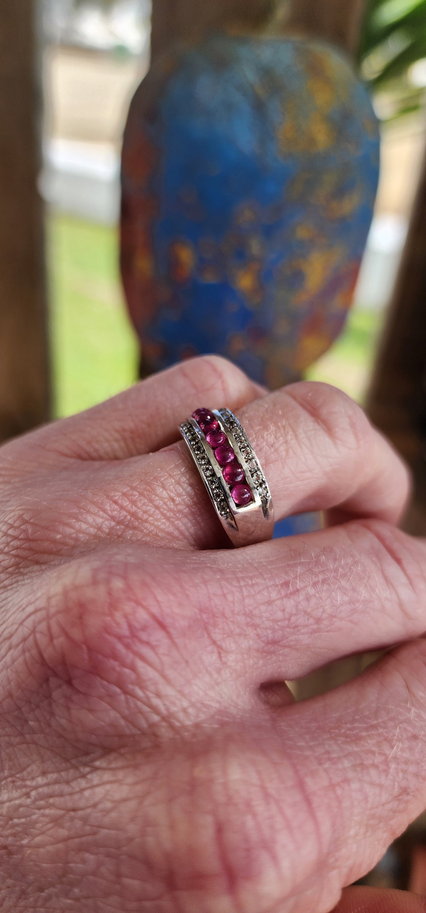 Classical 3 row Sterling Silver Art Deco style dress ring. Channel set with a row of 7 Ruby Cabochons in the centre and two rows of small Pave set CZ Gemstones on the sides.