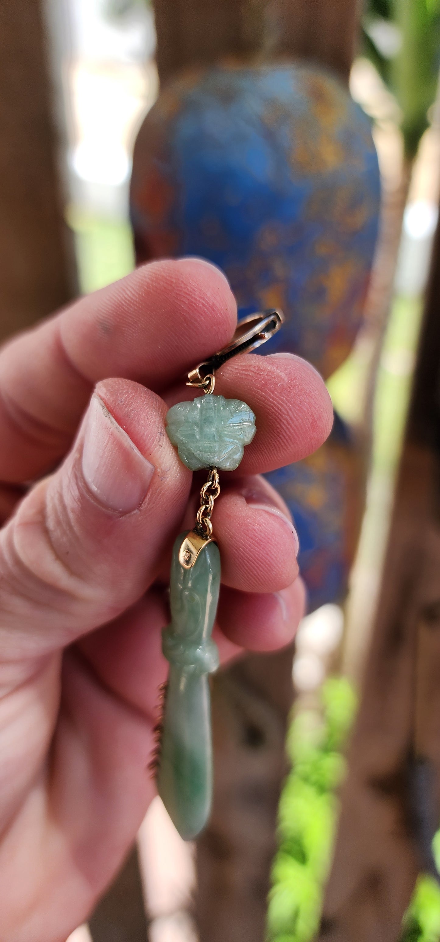 This pendant is a late Victorian-era piece featuring hand-carved jade and 9ct yellow gold. It’s crafted in the shape of a traditional Chinese nine-ring broadsword, with an apple-green jade blade.