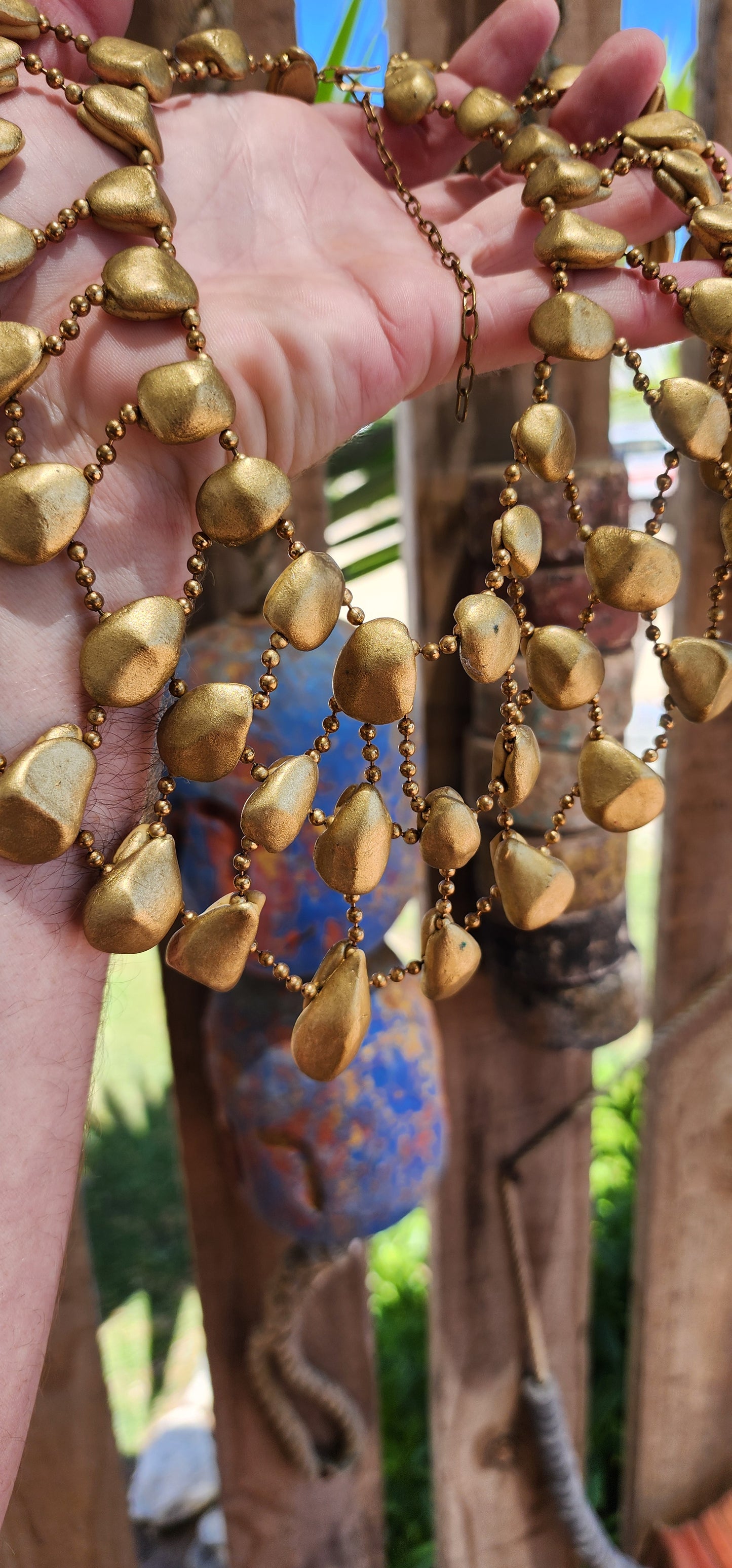 Get ready to channel your inner queen with this jaw-dropping artisan made statement necklace!Crafted from goldtone clay pebbles and Brass chains.