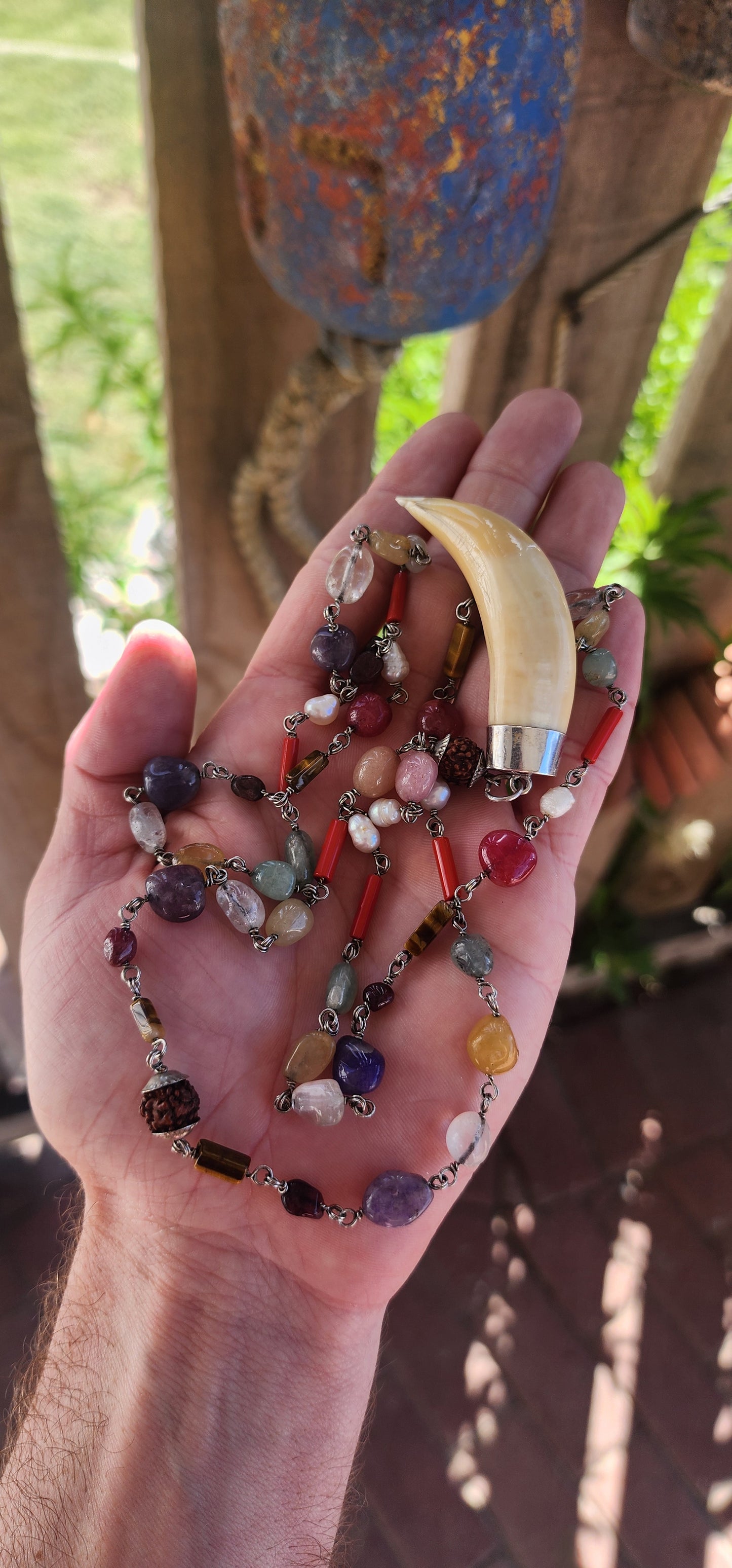 This extraordinary necklace is a harmonious blend of artistry. At its heart lies a large antique Victorian lion tooth pendant, encased in sterling silver, exuding a sense of primal strength and timeless elegance.