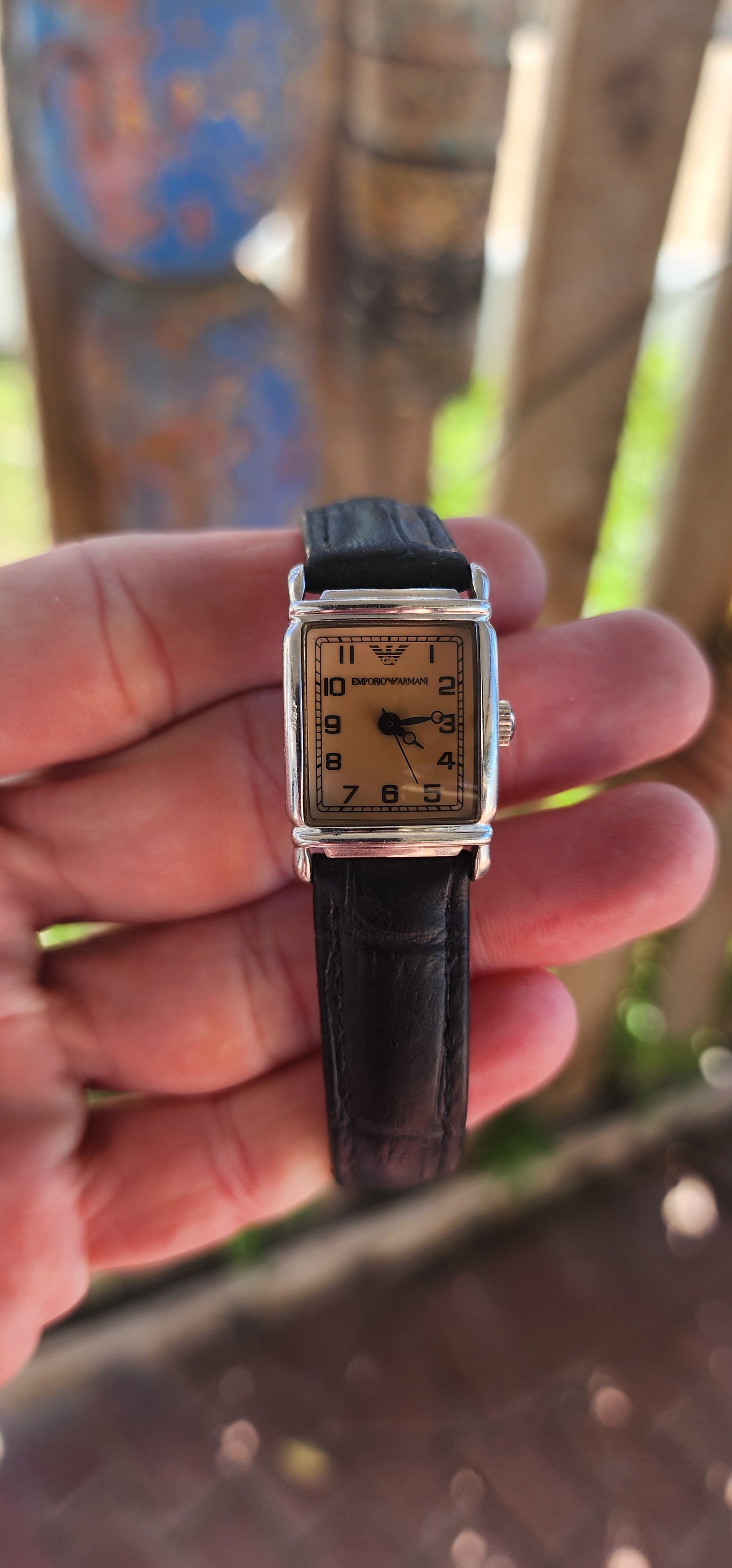 This elegant vintage Emporio Armani "AR0205" watch features a sophisticated vintage design with a rectangular stainless steel case and a beige analog dial.