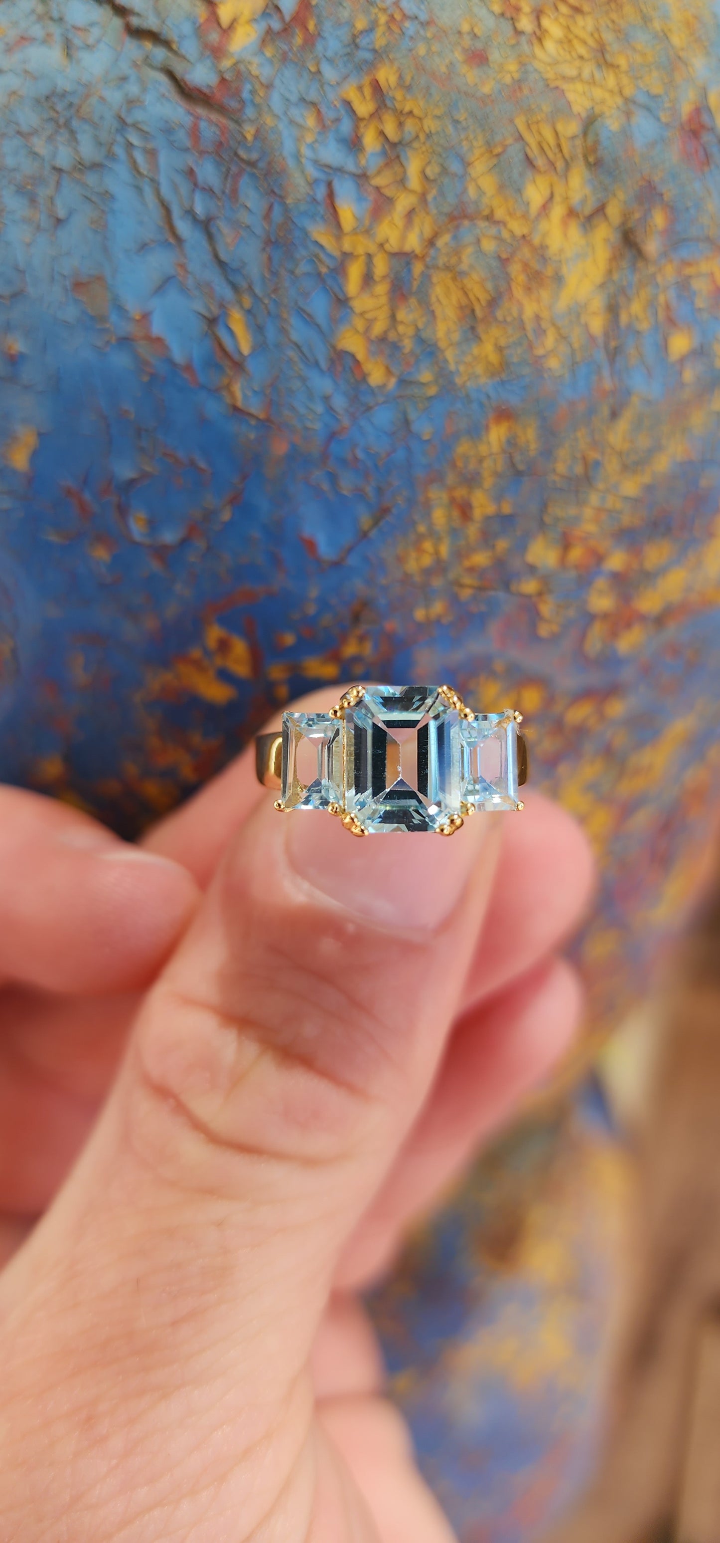 This extraordinary sterling silver trilogy ring, elegantly plated with 18ct yellow gold, radiates timeless sophistication and an ethereal charm.