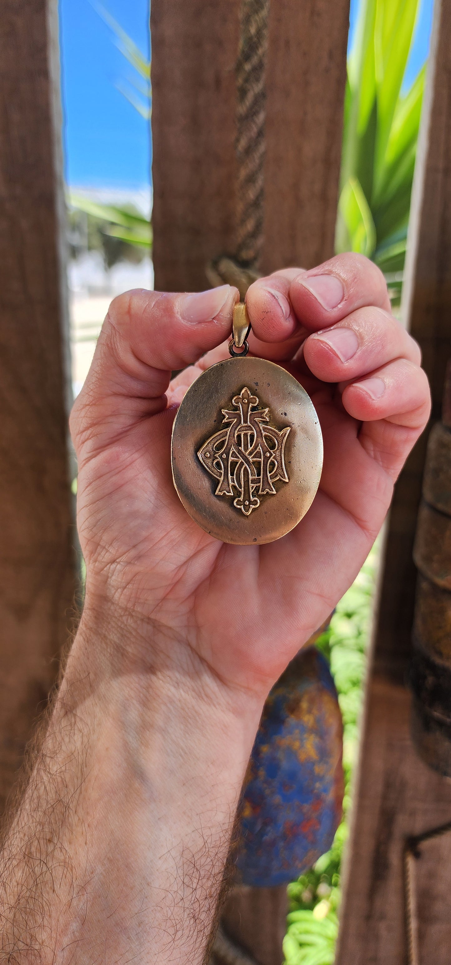 This remarkable piece is a large Victorian-era brass sweetheart locket, crafted in an elegant oval form and adorned with a striking raised monogram, "AEI." Standing for Amity (Affinity), Eternity, and Infinity.