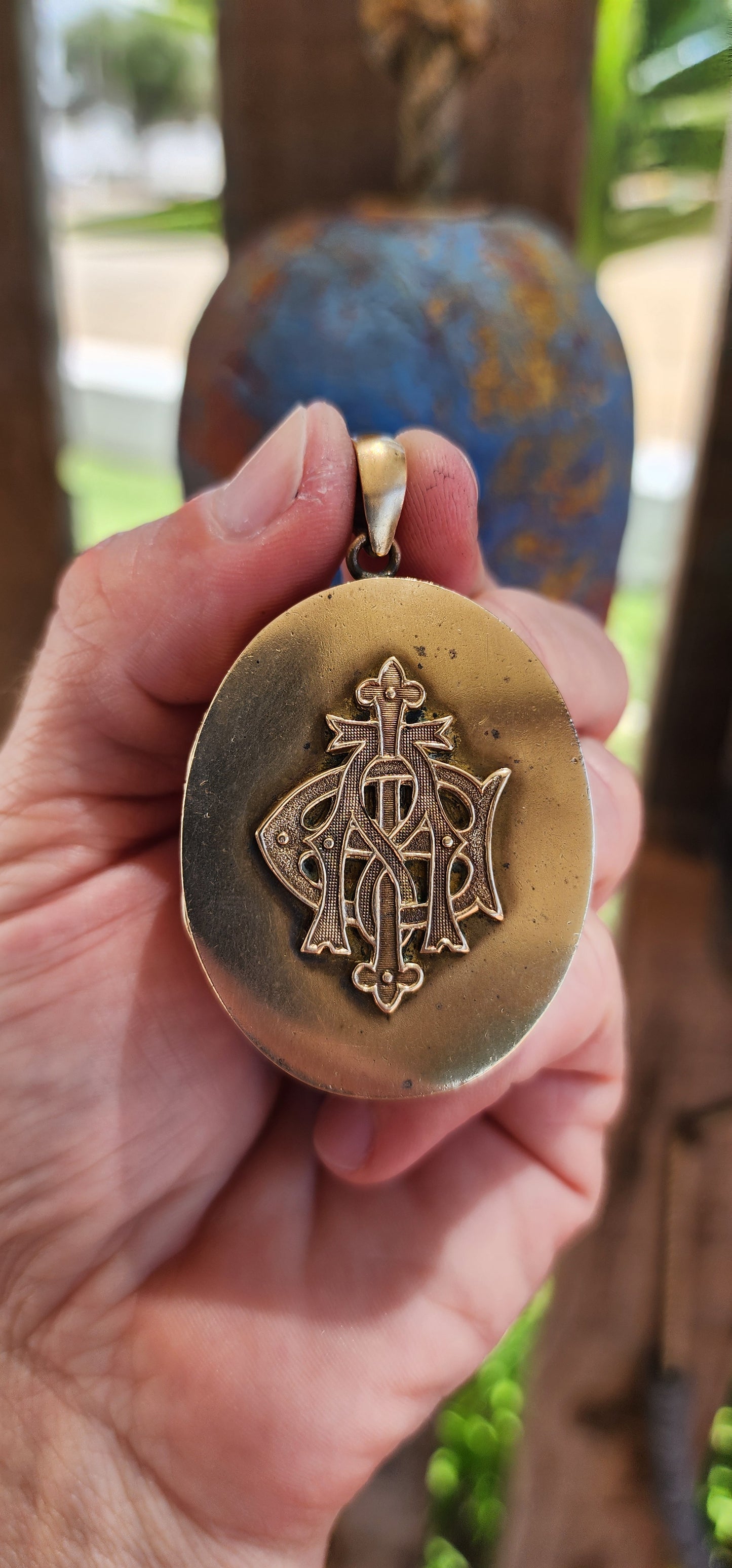 This remarkable piece is a large Victorian-era brass sweetheart locket, crafted in an elegant oval form and adorned with a striking raised monogram, "AEI." Standing for Amity (Affinity), Eternity, and Infinity.