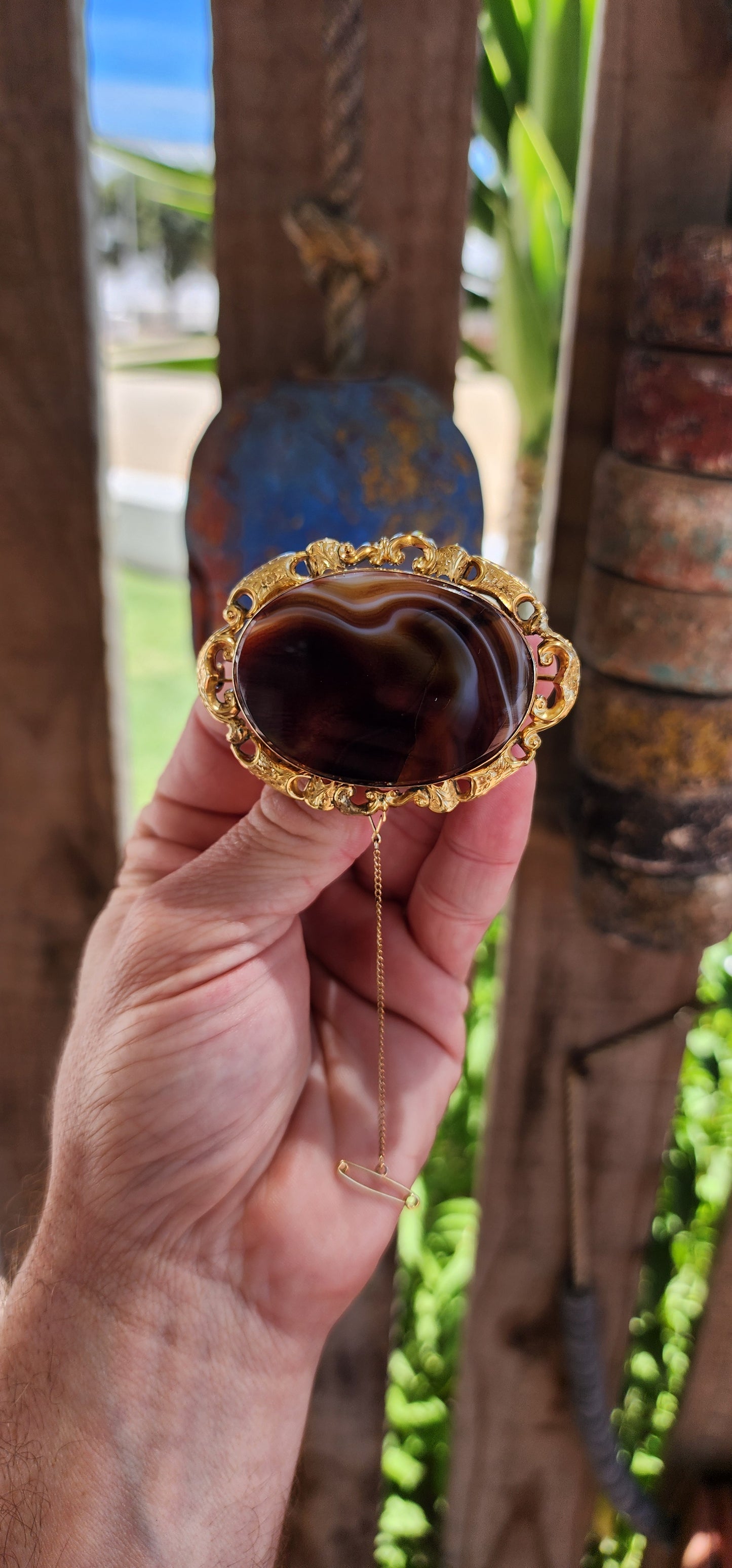 This oversized brooch is a fine example of an Antique Victorian-era Scottish banded agate brooch, crafted in 10ct yellow gold and featuring a large, polished oval banded agate at its center.