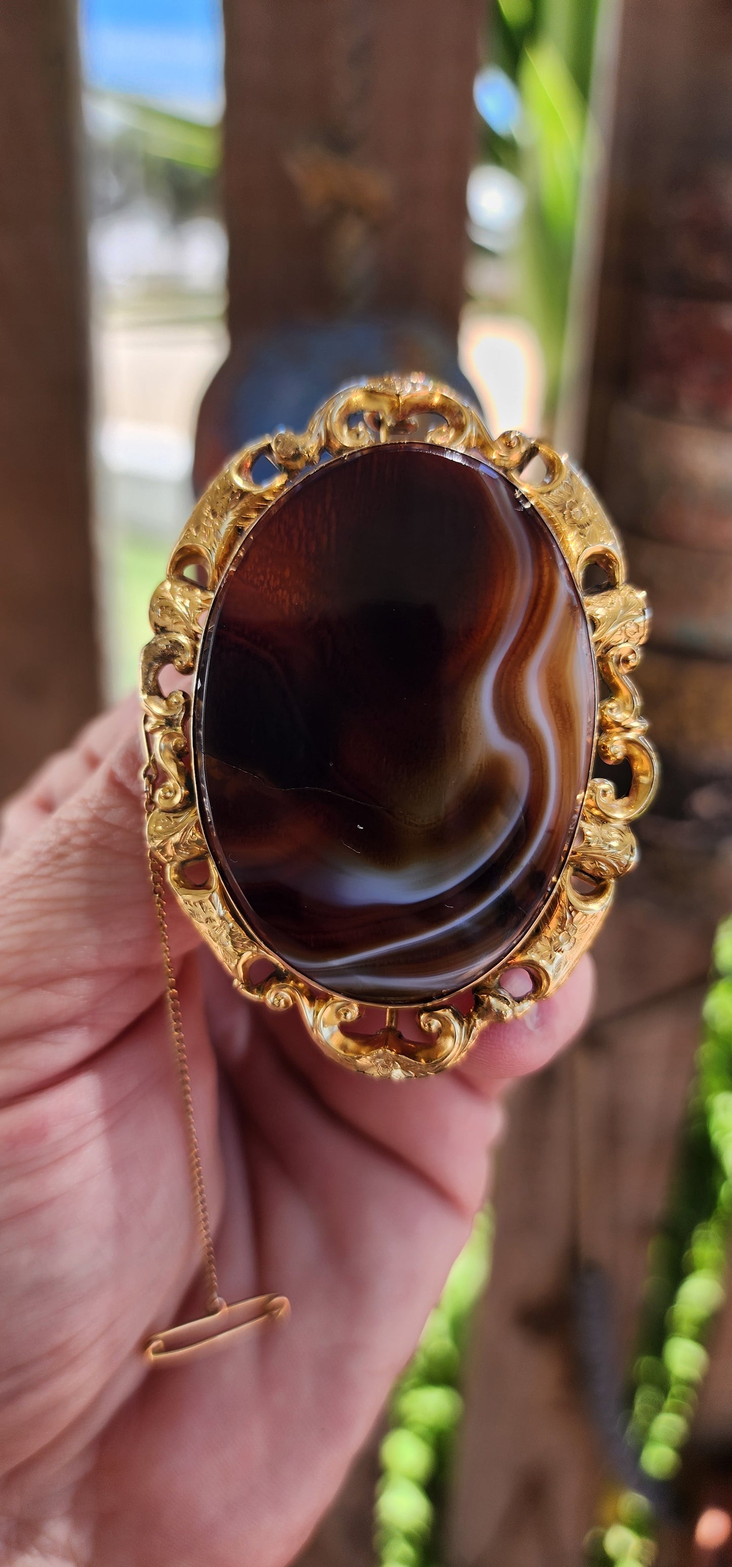 This oversized brooch is a fine example of an Antique Victorian-era Scottish banded agate brooch, crafted in 10ct yellow gold and featuring a large, polished oval banded agate at its center.