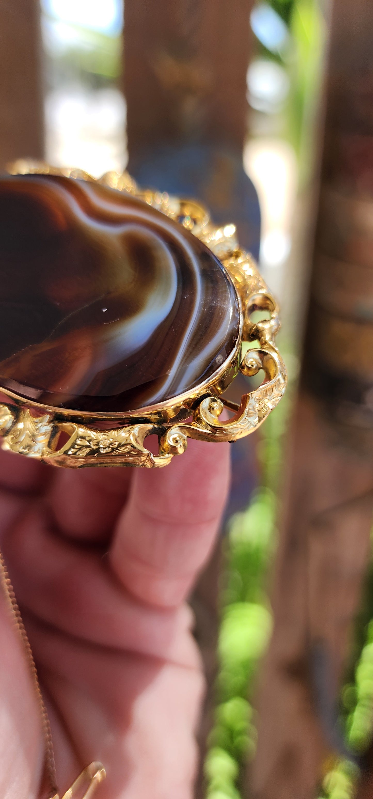 This oversized brooch is a fine example of an Antique Victorian-era Scottish banded agate brooch, crafted in 10ct yellow gold and featuring a large, polished oval banded agate at its center.