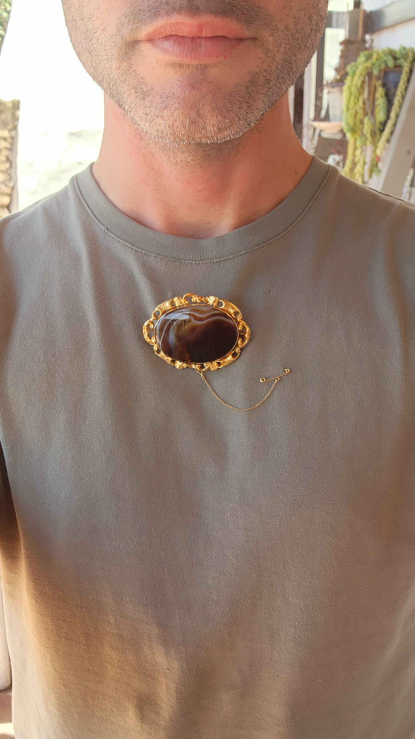 This oversized brooch is a fine example of an Antique Victorian-era Scottish banded agate brooch, crafted in 10ct yellow gold and featuring a large, polished oval banded agate at its center.