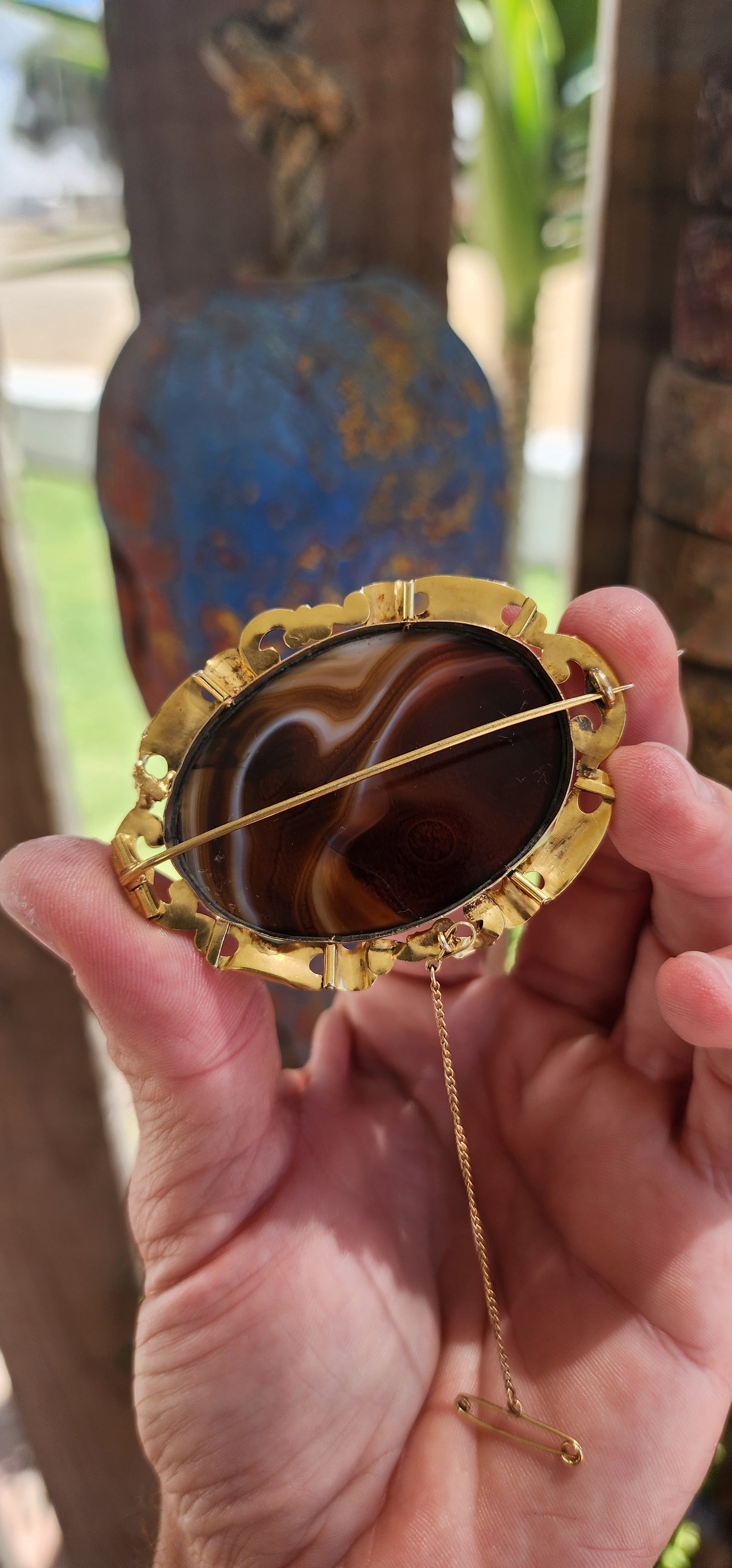 This oversized brooch is a fine example of an Antique Victorian-era Scottish banded agate brooch, crafted in 10ct yellow gold and featuring a large, polished oval banded agate at its center.