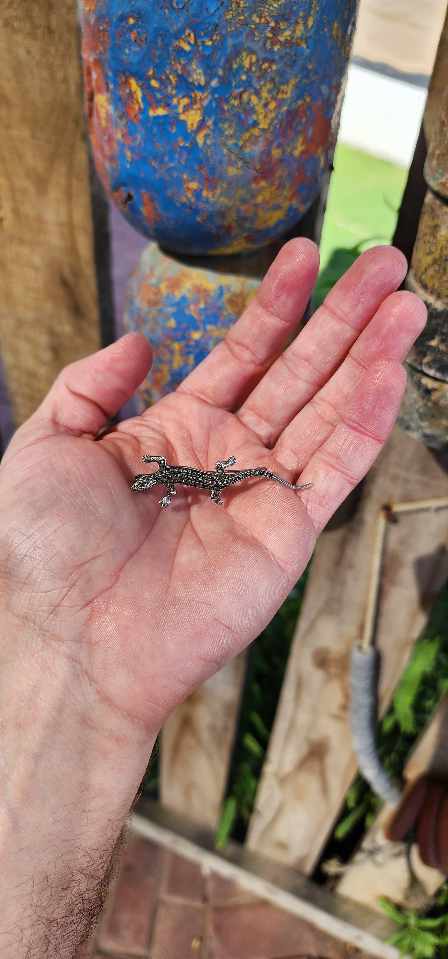 This stunning piece of wearable history is an Art Deco-era brooch from the 1930s, crafted in 835 silver and set with glittering marcasite gemstones and green emerald paste rhinestones.