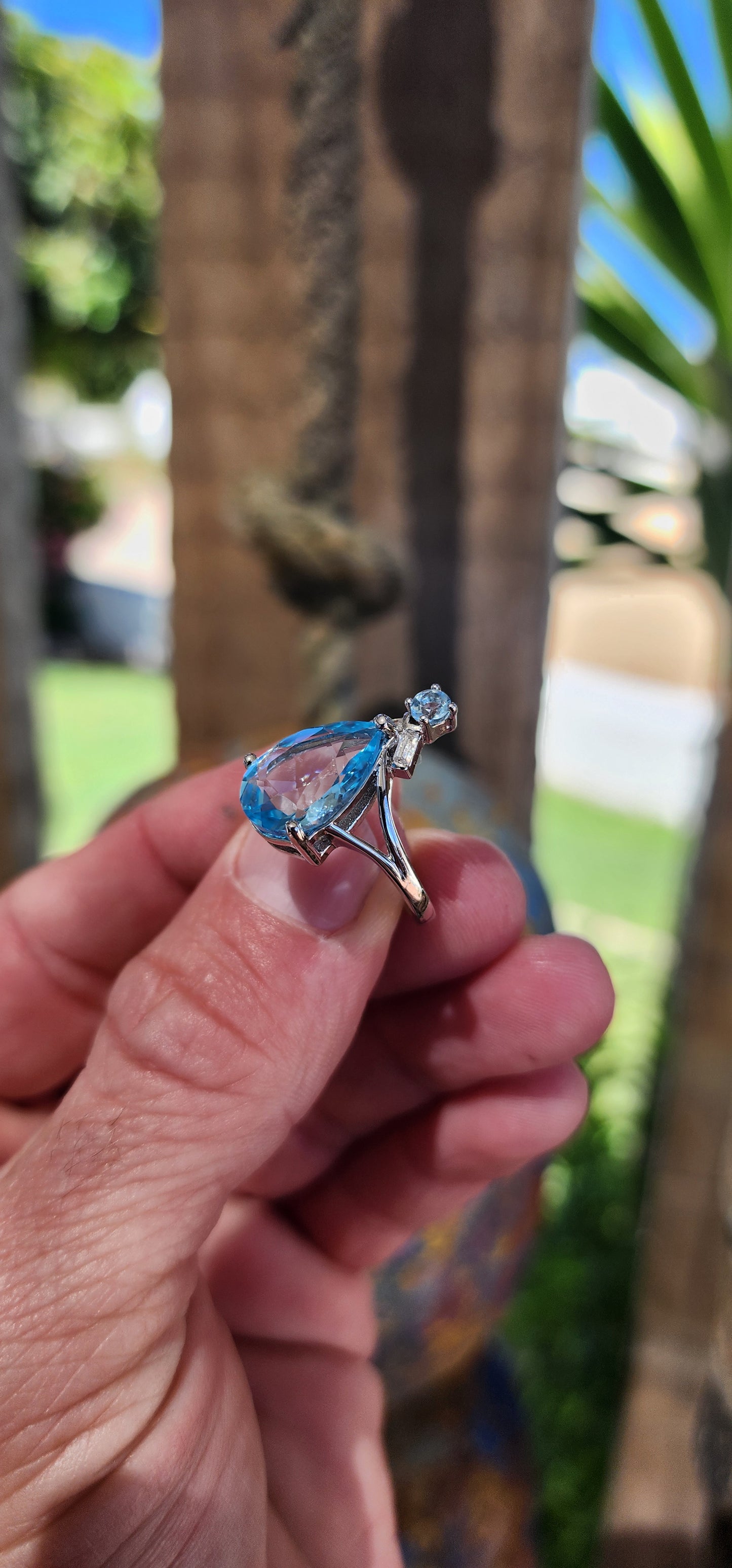 This Art Deco-inspired sterling silver ring is an absolute showstopper! At its heart lies a stunning, pear-cut Swiss blue topaz that radiates an ocean-like brilliance, its generous size drawing all eyes to its dazzling hue.