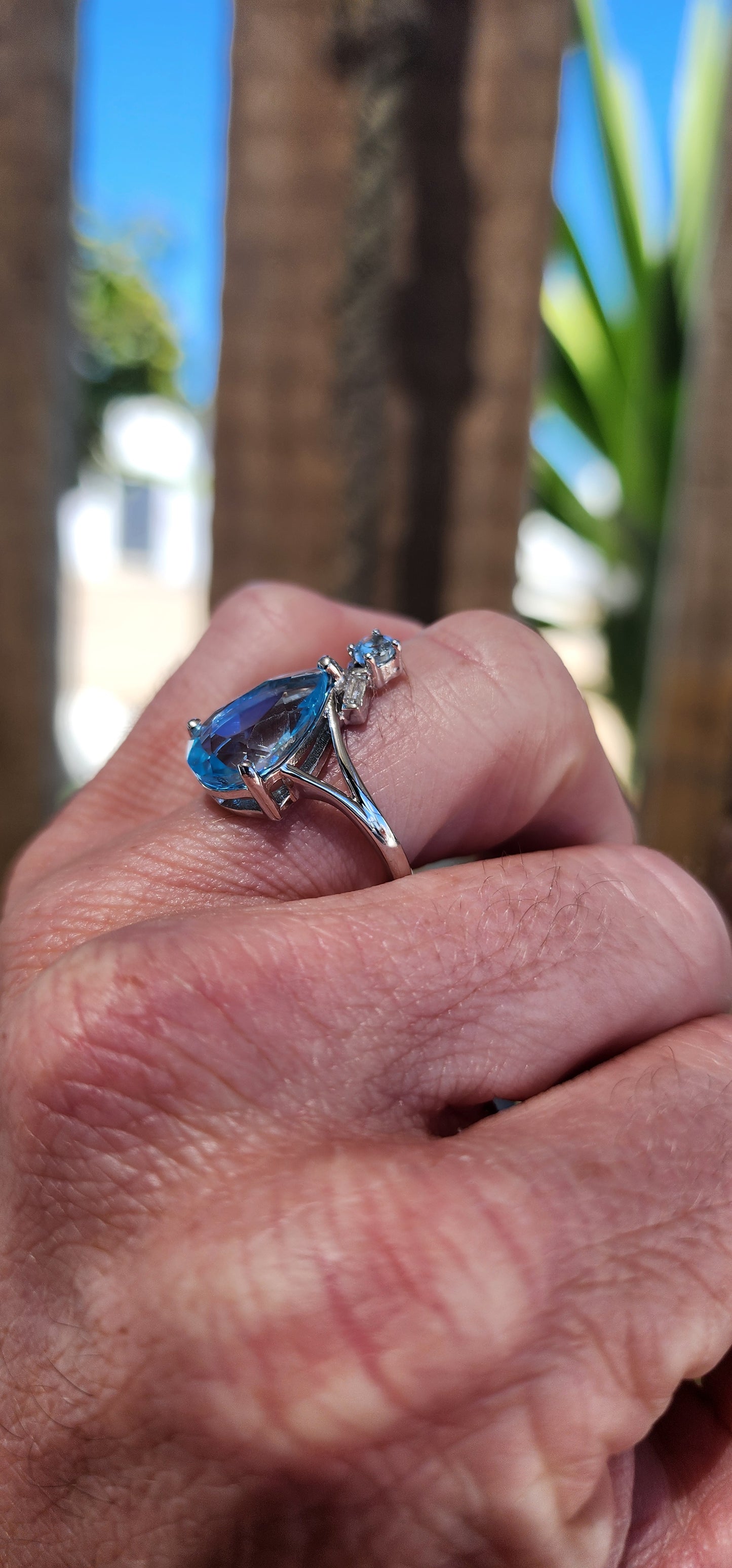This Art Deco-inspired sterling silver ring is an absolute showstopper! At its heart lies a stunning, pear-cut Swiss blue topaz that radiates an ocean-like brilliance, its generous size drawing all eyes to its dazzling hue.