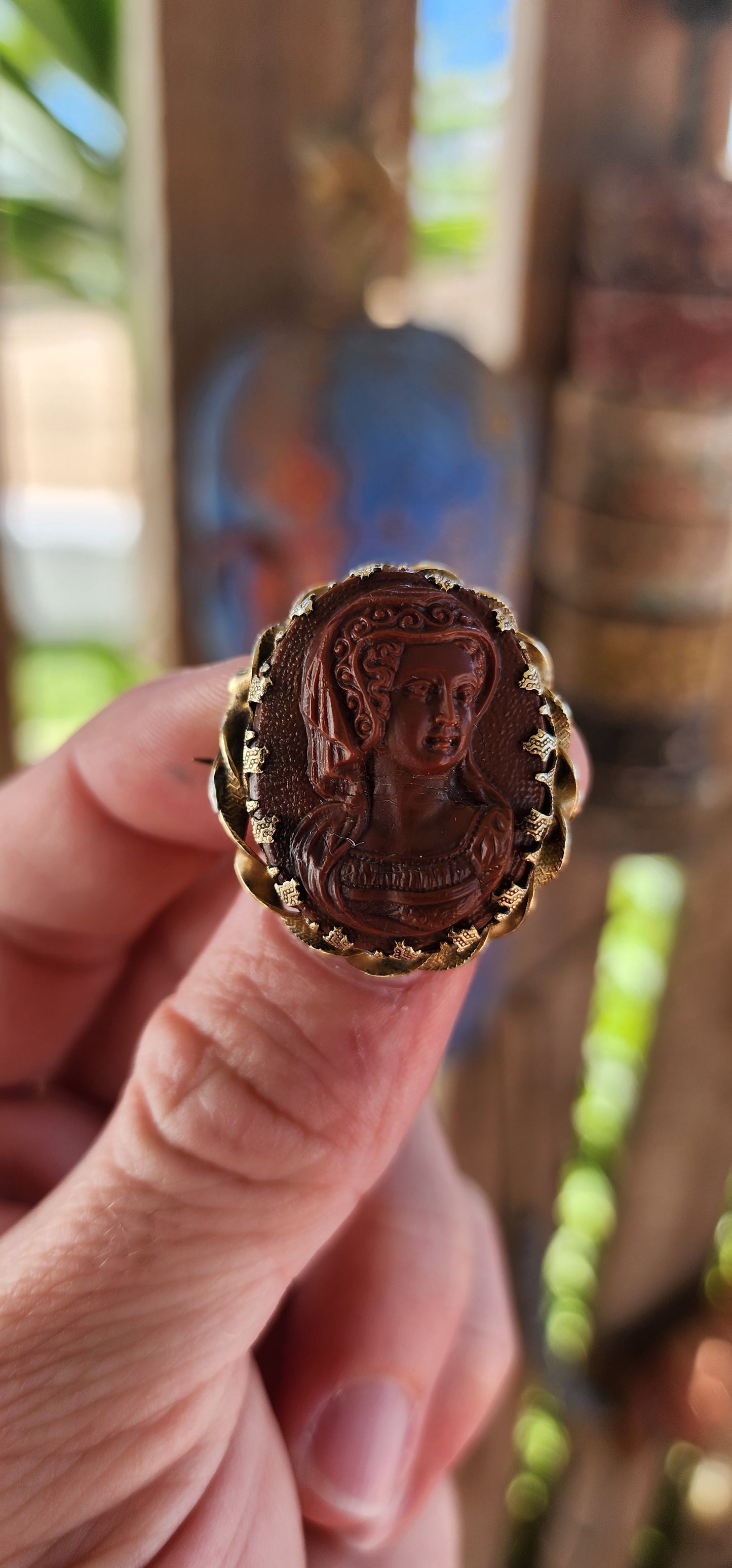 This exquisite antique late 18th-century brooch is a finely crafted example of Georgian-era jewelry, featuring a high-relief glass cameo depicting a noblewoman in period attire.