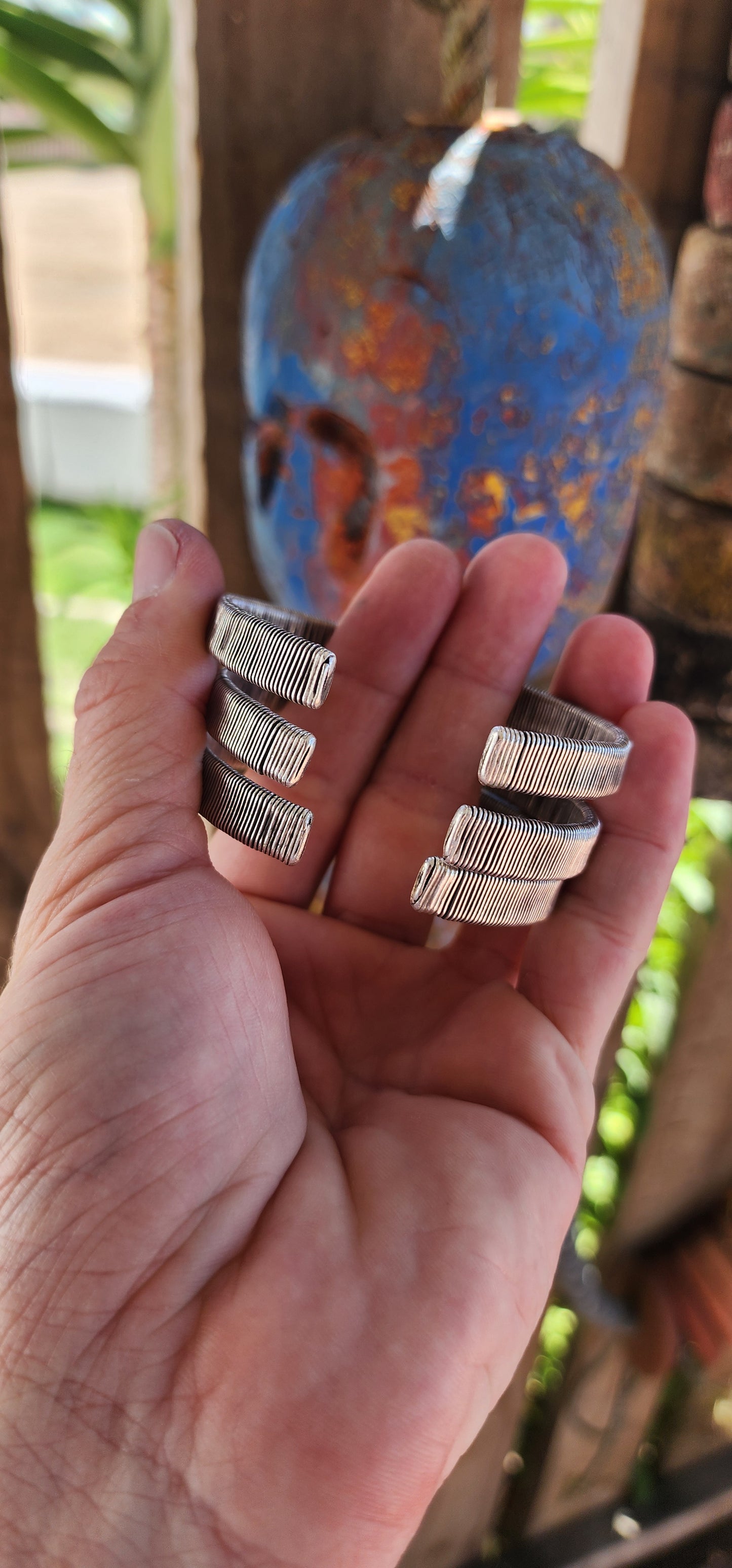 These bangles are a lot of three vintage Karen Hill Tribe open cuff bangles, crafted from solid 999 silver. Their weighty and solid nature, along with the intricate wrapped wire design, makes them unique pieces with both aesthetic and cultural value.