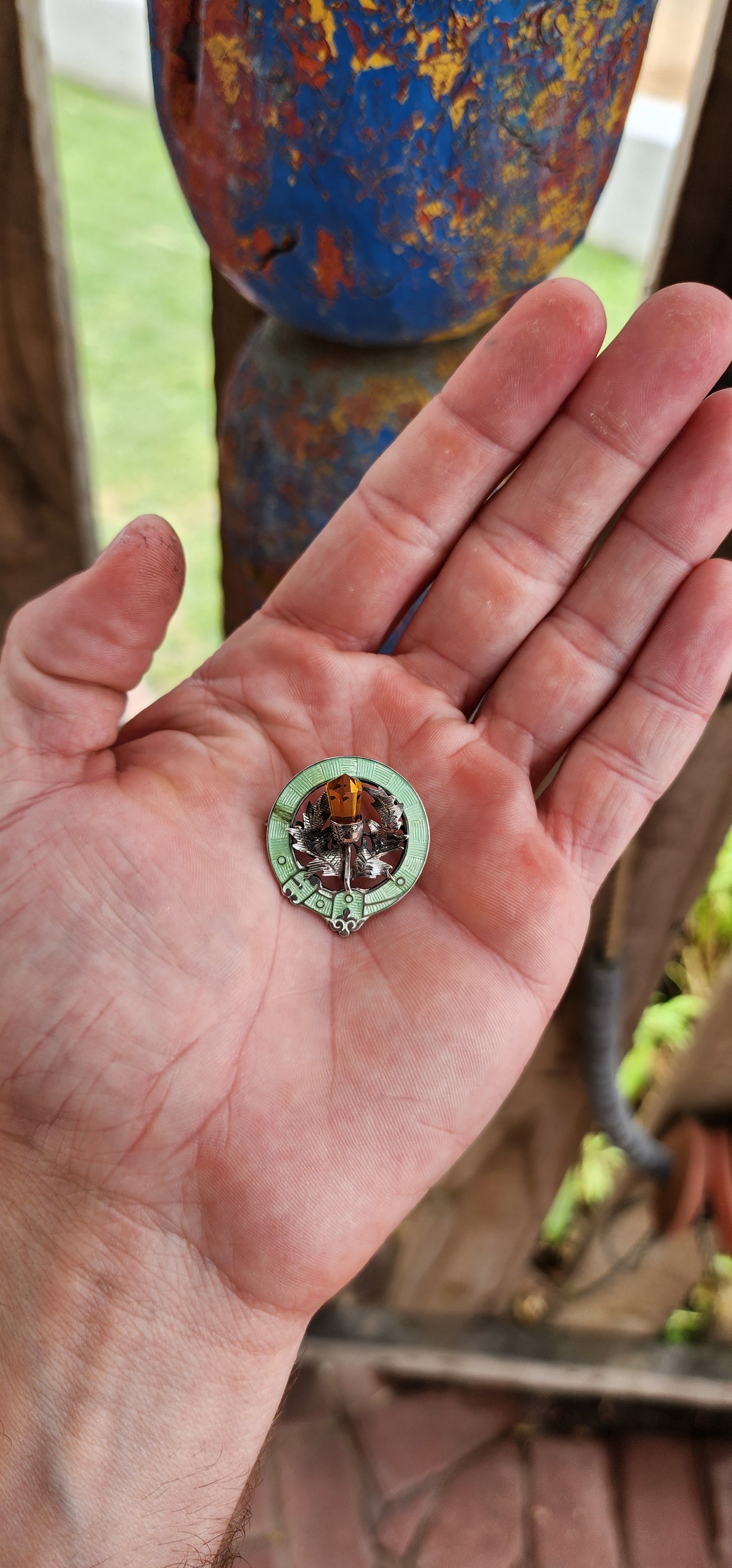 This antique Scottish brooch from circa 1916, made by Adie & Lovekin Ltd in Chester, is a remarkable piece featuring hallmarked sterling silver, citrine, and rare lime-green guilloché enamel.