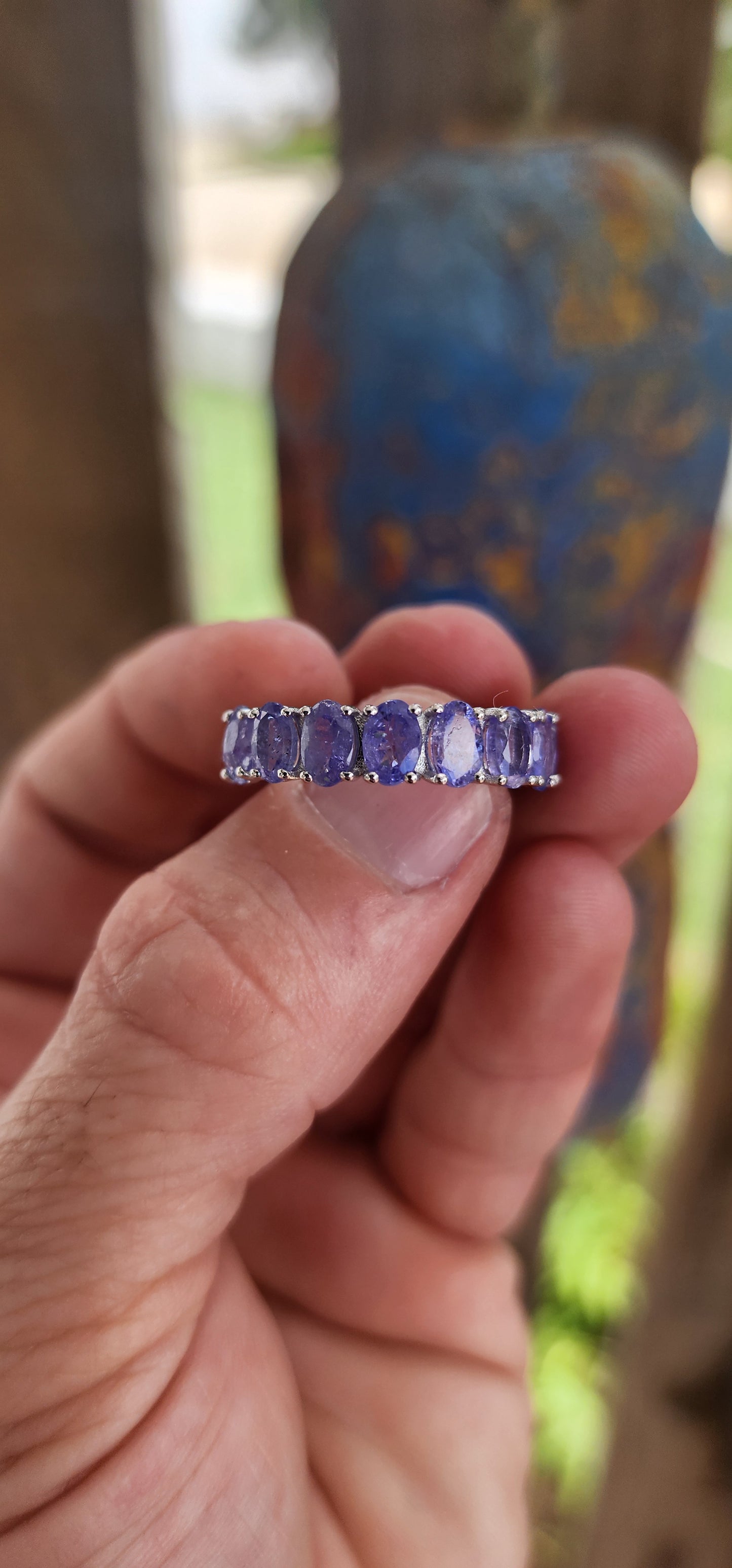 This exquisite full eternity ring is a testament to masterful craftsmanship and timeless elegance. Expertly forged in polished sterling silver, the ring showcases a seamless circle of 17 oval-cut Tanzanite gemstones.