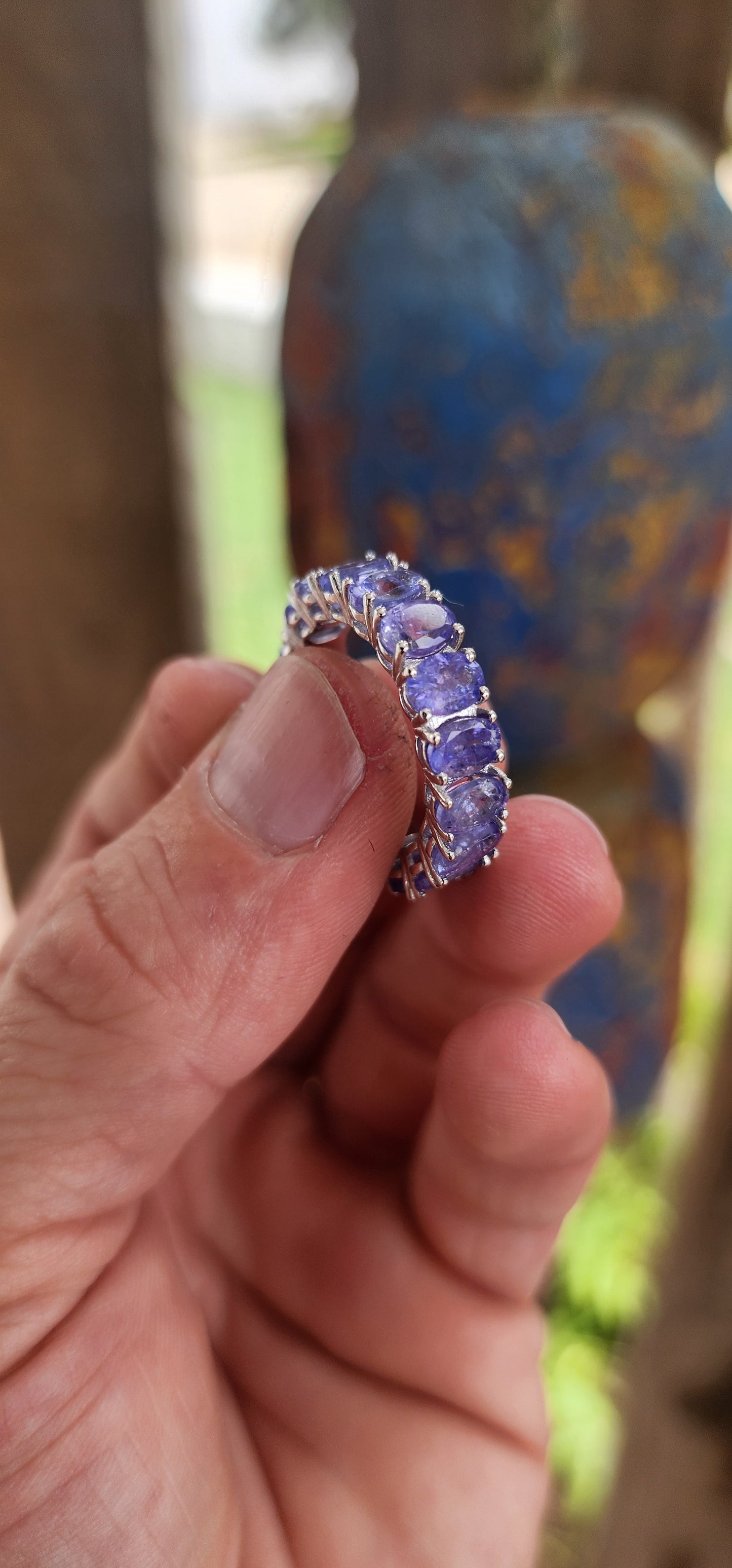This exquisite full eternity ring is a testament to masterful craftsmanship and timeless elegance. Expertly forged in polished sterling silver, the ring showcases a seamless circle of 17 oval-cut Tanzanite gemstones.