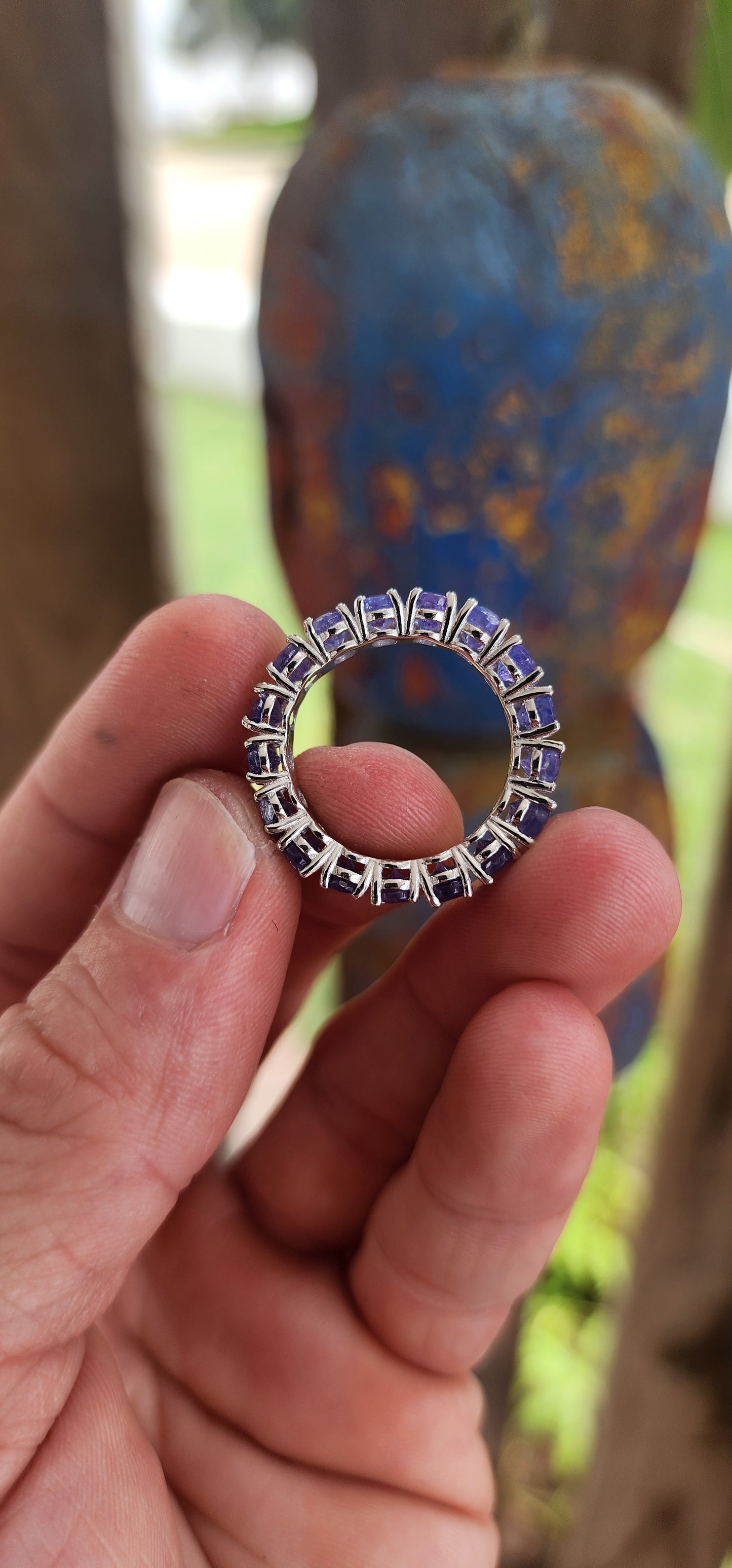 This exquisite full eternity ring is a testament to masterful craftsmanship and timeless elegance. Expertly forged in polished sterling silver, the ring showcases a seamless circle of 17 oval-cut Tanzanite gemstones.