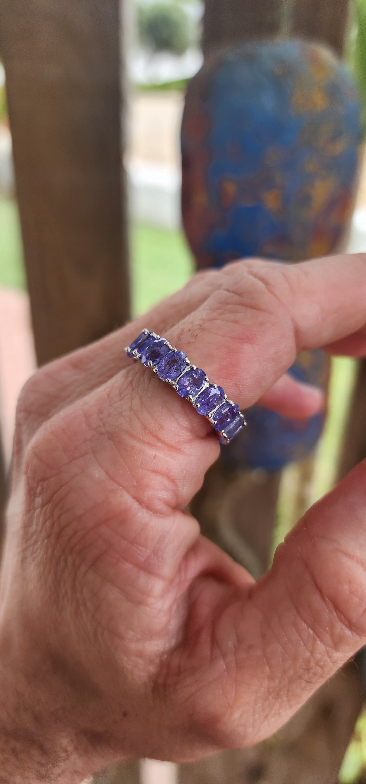 This exquisite full eternity ring is a testament to masterful craftsmanship and timeless elegance. Expertly forged in polished sterling silver, the ring showcases a seamless circle of 17 oval-cut Tanzanite gemstones.