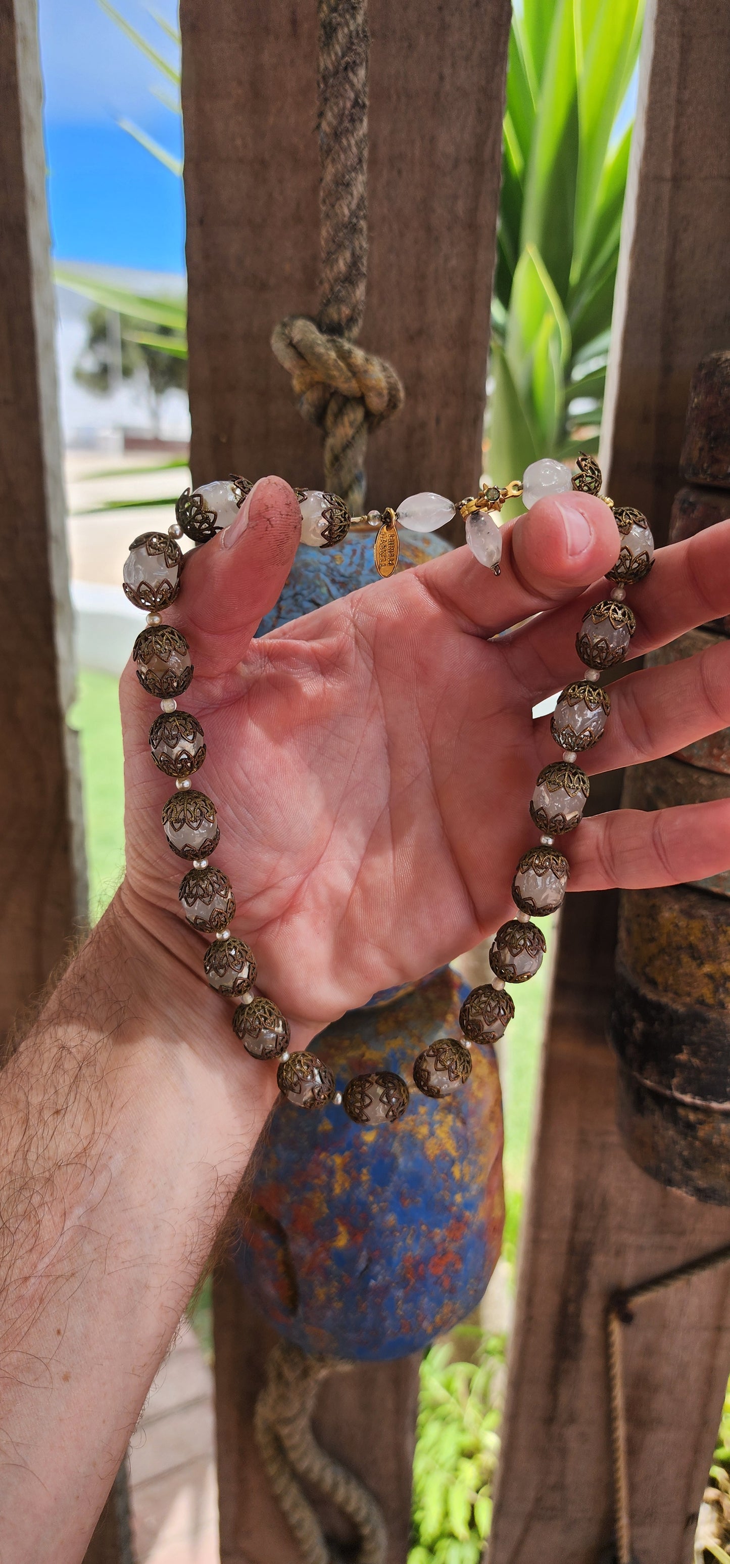 This exquisite Miriam Haskell costume necklace is a vintage choker-length piece from the 1970s, featuring opaque clear glass beads that are capped with ornate brass filigree.