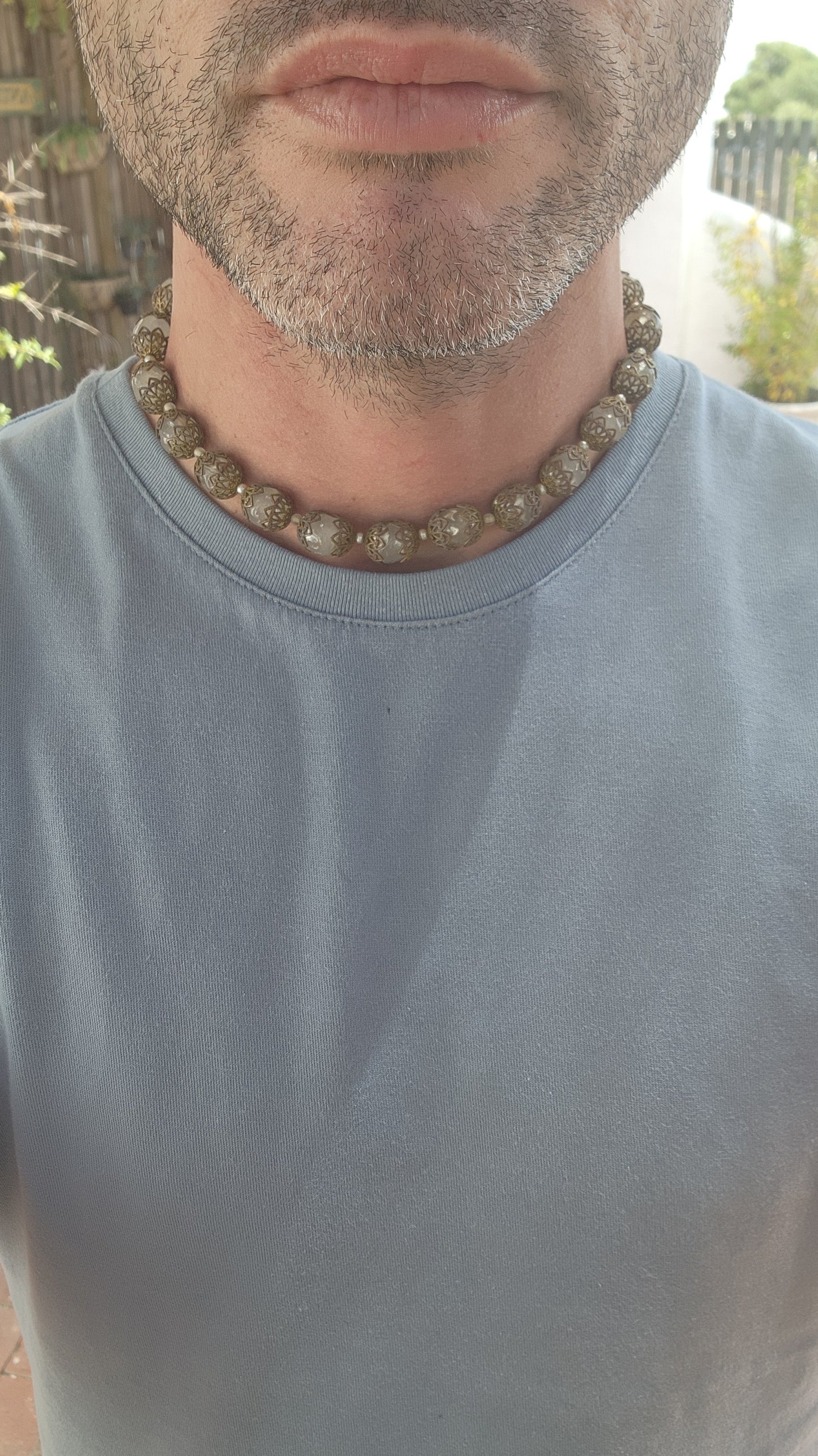 This exquisite Miriam Haskell costume necklace is a vintage choker-length piece from the 1970s, featuring opaque clear glass beads that are capped with ornate brass filigree.