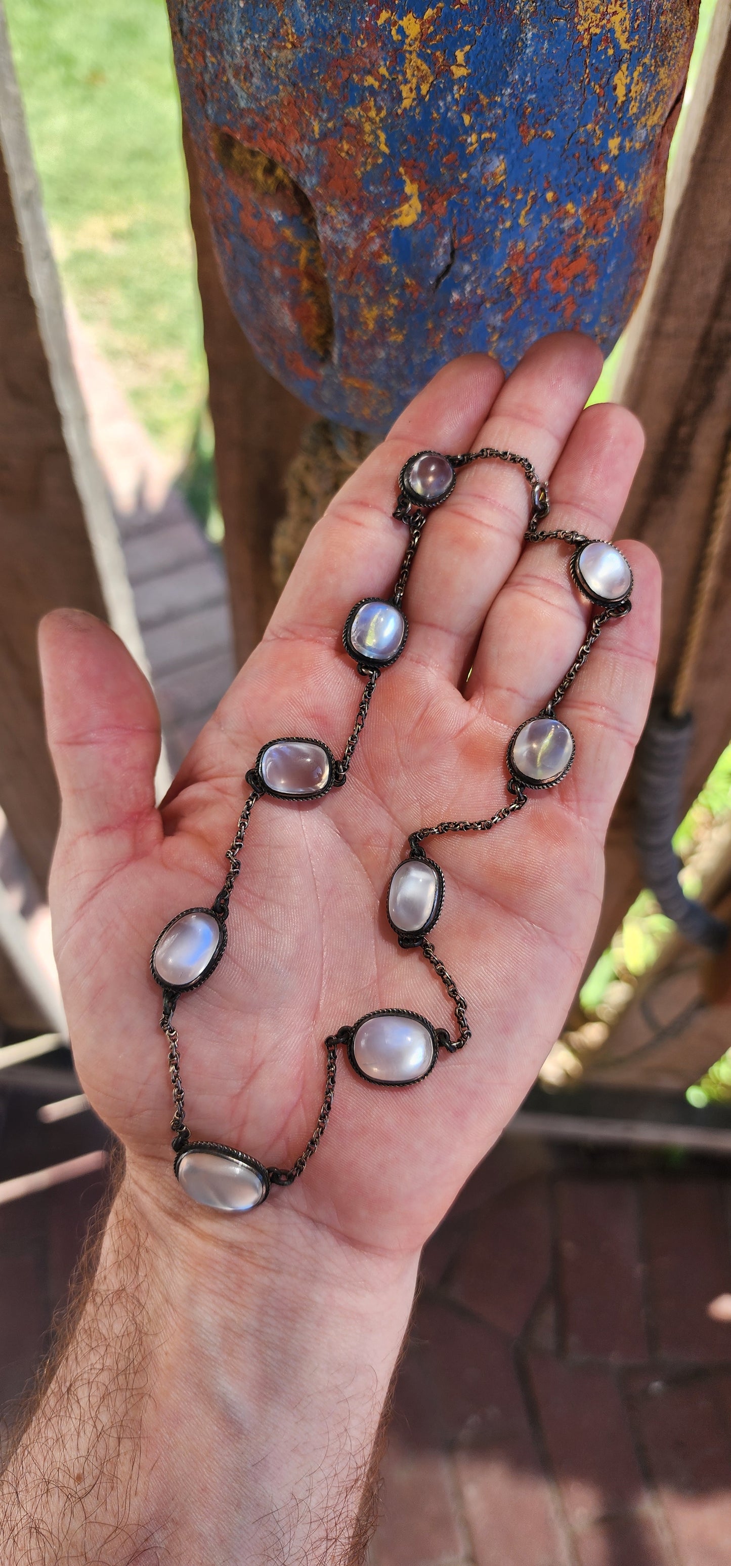 This exquisite antique moonstone rivière style necklace is a prime example of late Victorian to early Edwardian jewelry, specifically reflecting the principles of the Arts & Crafts movement (c. 1890–1910).