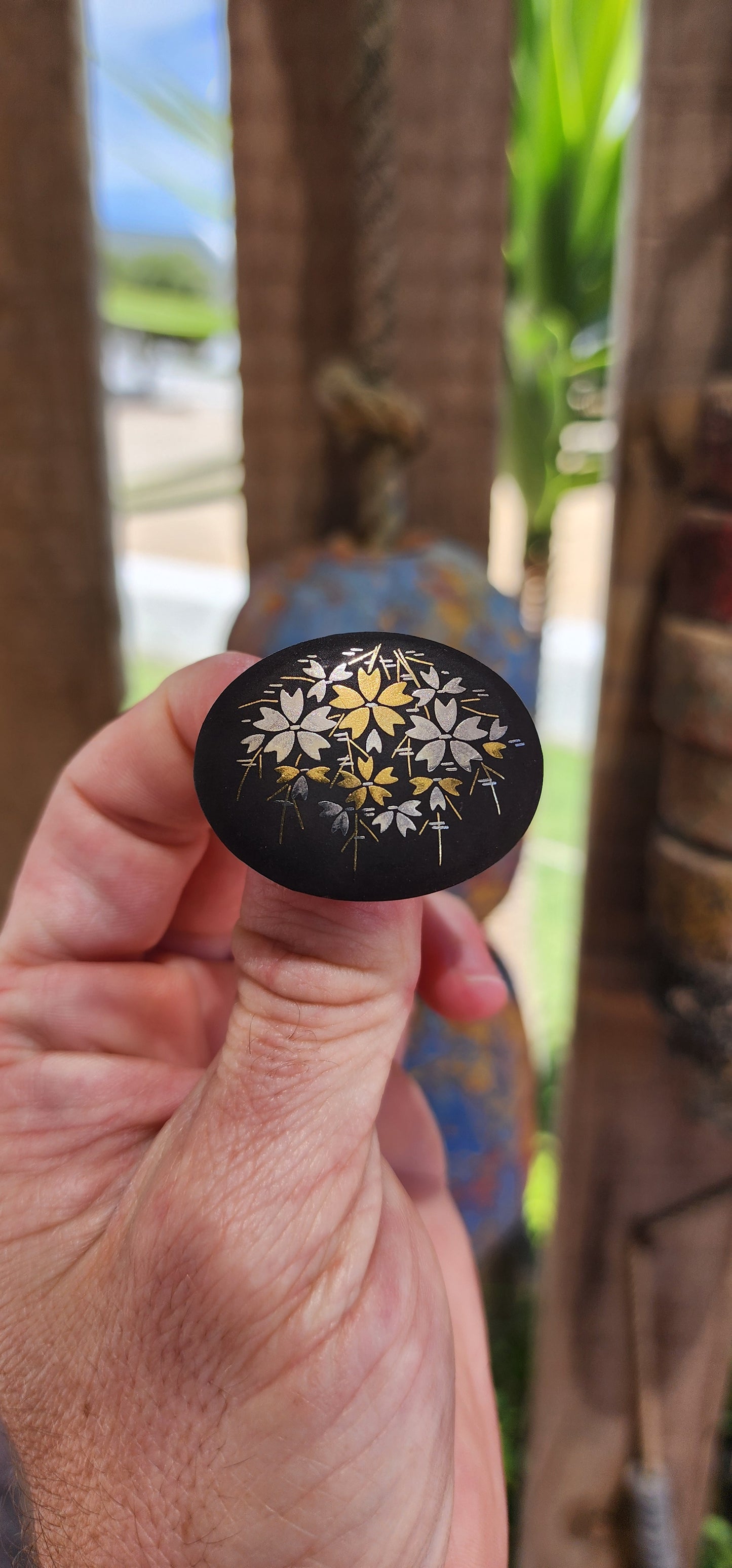 This brooch is an authentic vintage Japanese Amita Damascene brooch, showcasing a gold and silver floral motif intricately inlaid into a blackened metal base.