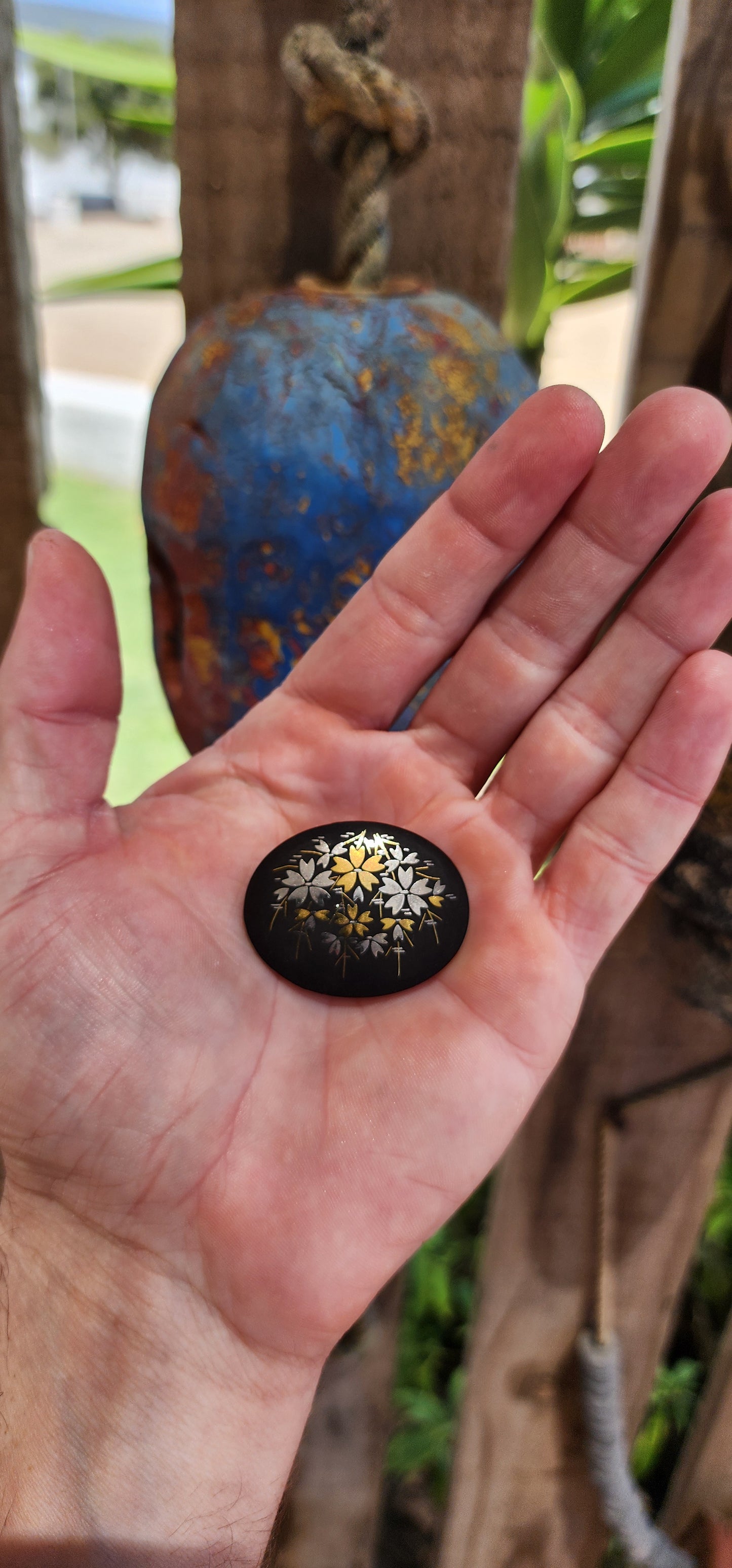 This brooch is an authentic vintage Japanese Amita Damascene brooch, showcasing a gold and silver floral motif intricately inlaid into a blackened metal base.