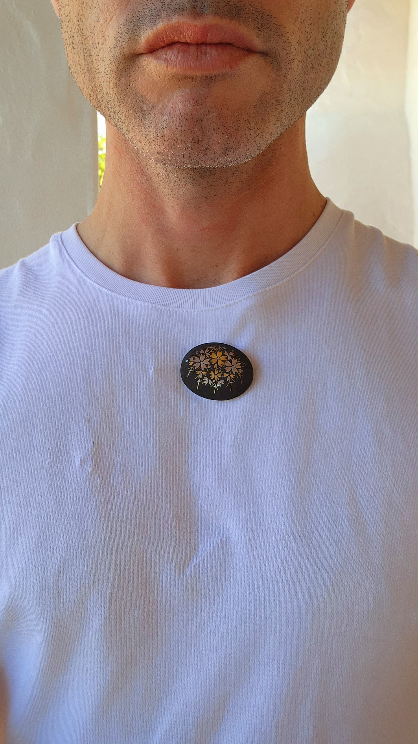 This brooch is an authentic vintage Japanese Amita Damascene brooch, showcasing a gold and silver floral motif intricately inlaid into a blackened metal base.