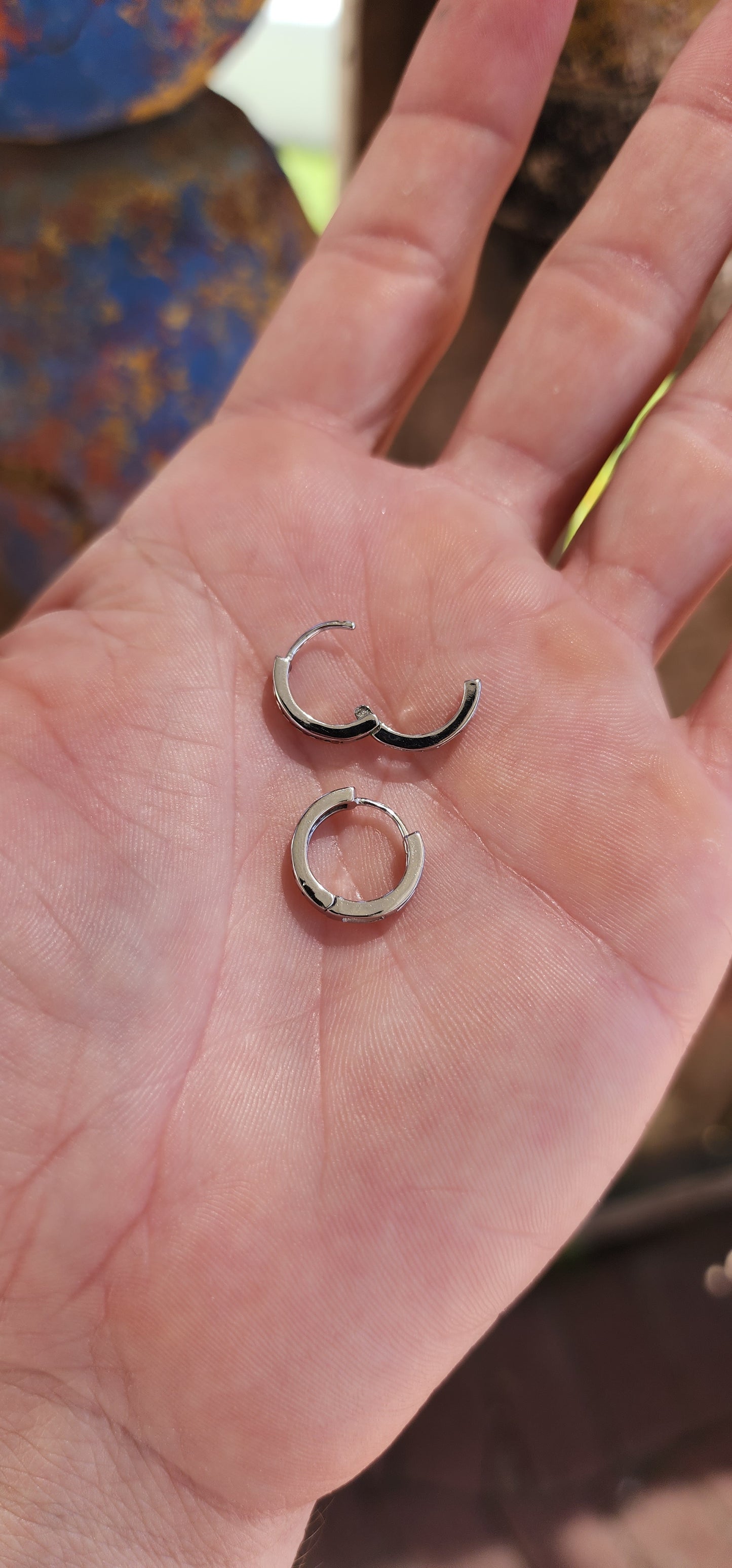 These petite sterling silver hoop earrings are like tiny sunsets, blending classic elegance with a fiery touch of color.