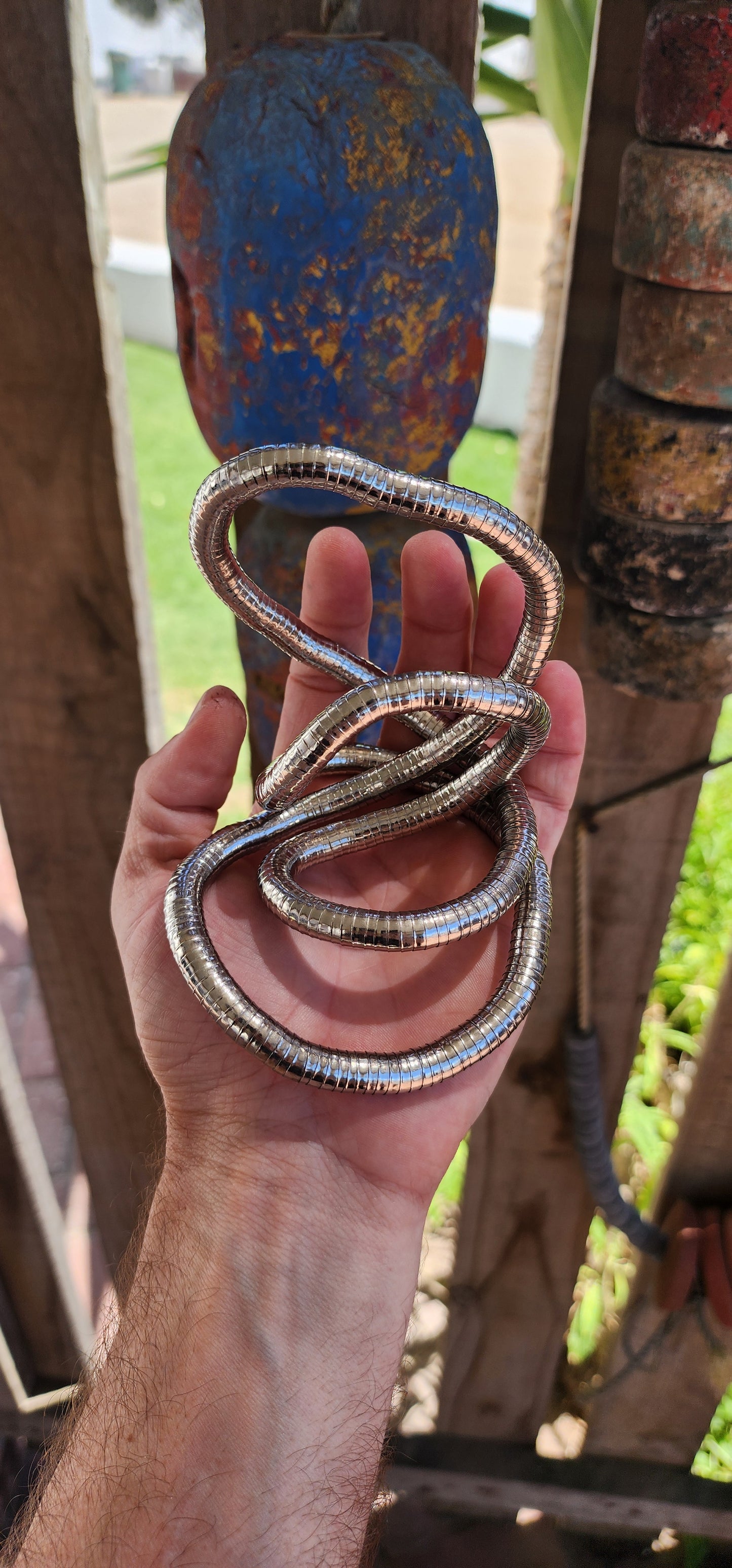 This vintage 90's silvertone transformer snake necklace is a remarkable fusion of modernist design and playful versatility, making it a standout in the world of articulated jewelry.