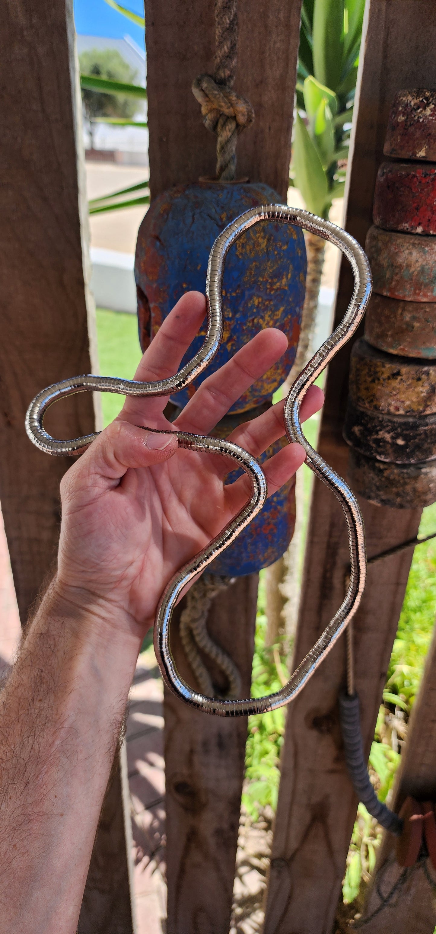 This vintage 90's silvertone transformer snake necklace is a remarkable fusion of modernist design and playful versatility, making it a standout in the world of articulated jewelry.