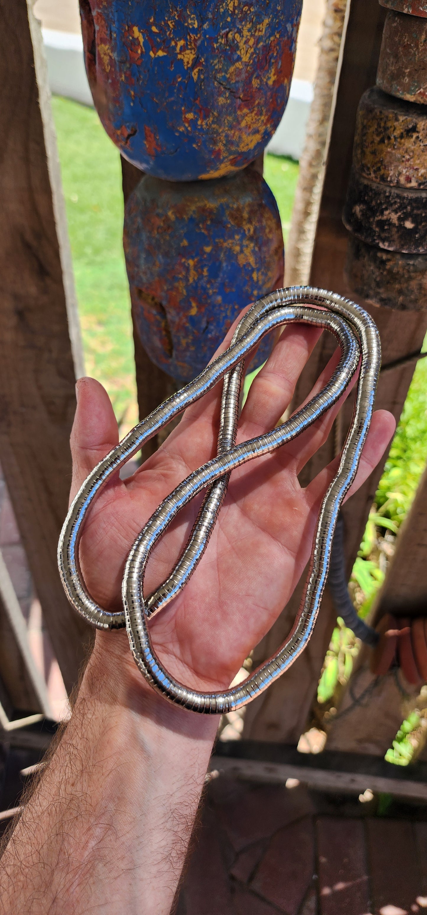 This vintage 90's silvertone transformer snake necklace is a remarkable fusion of modernist design and playful versatility, making it a standout in the world of articulated jewelry.