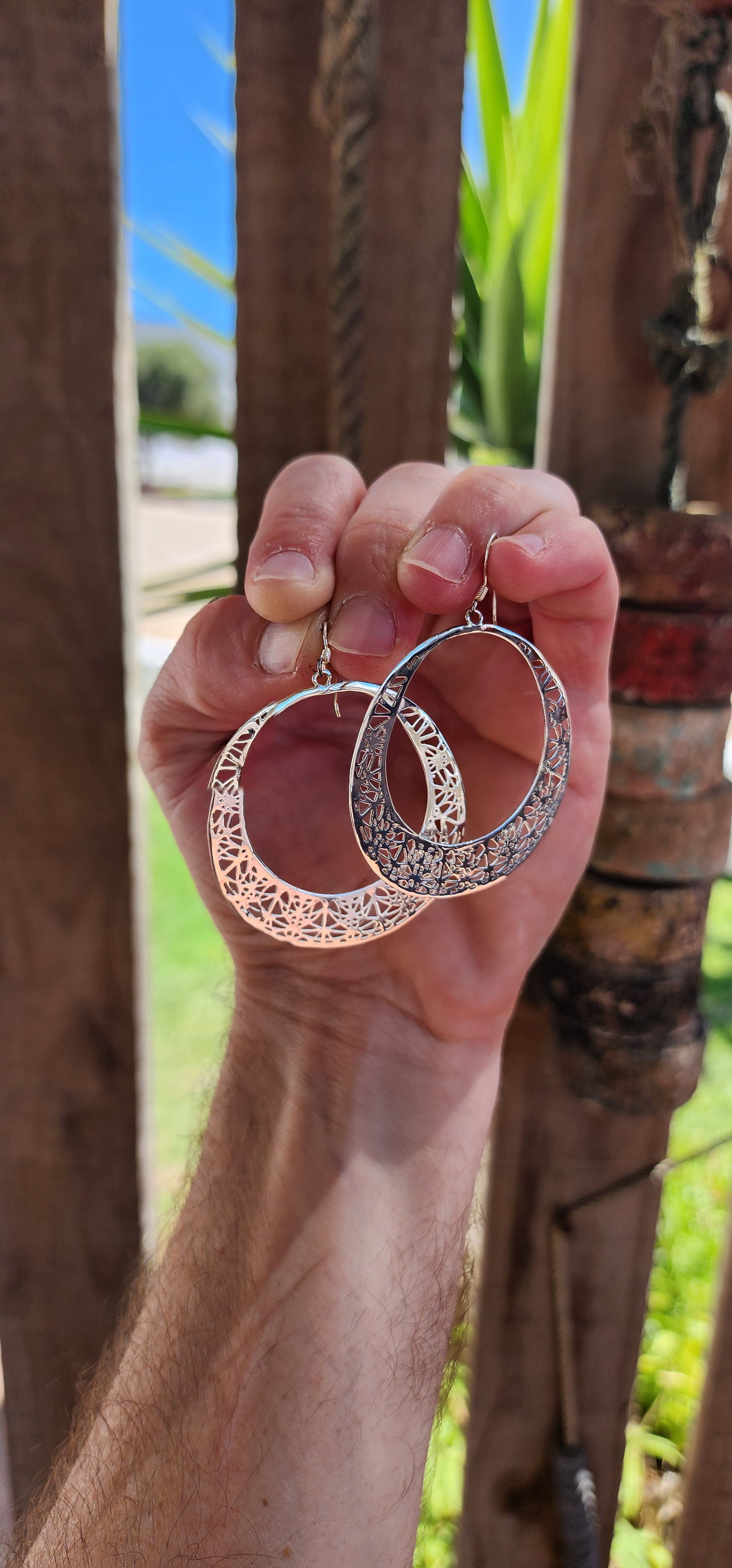 These oversized sterling silver hoop dangle earrings are an exquisite example of fine craftsmanship, blending timeless elegance with a touch of intricate artistry.
