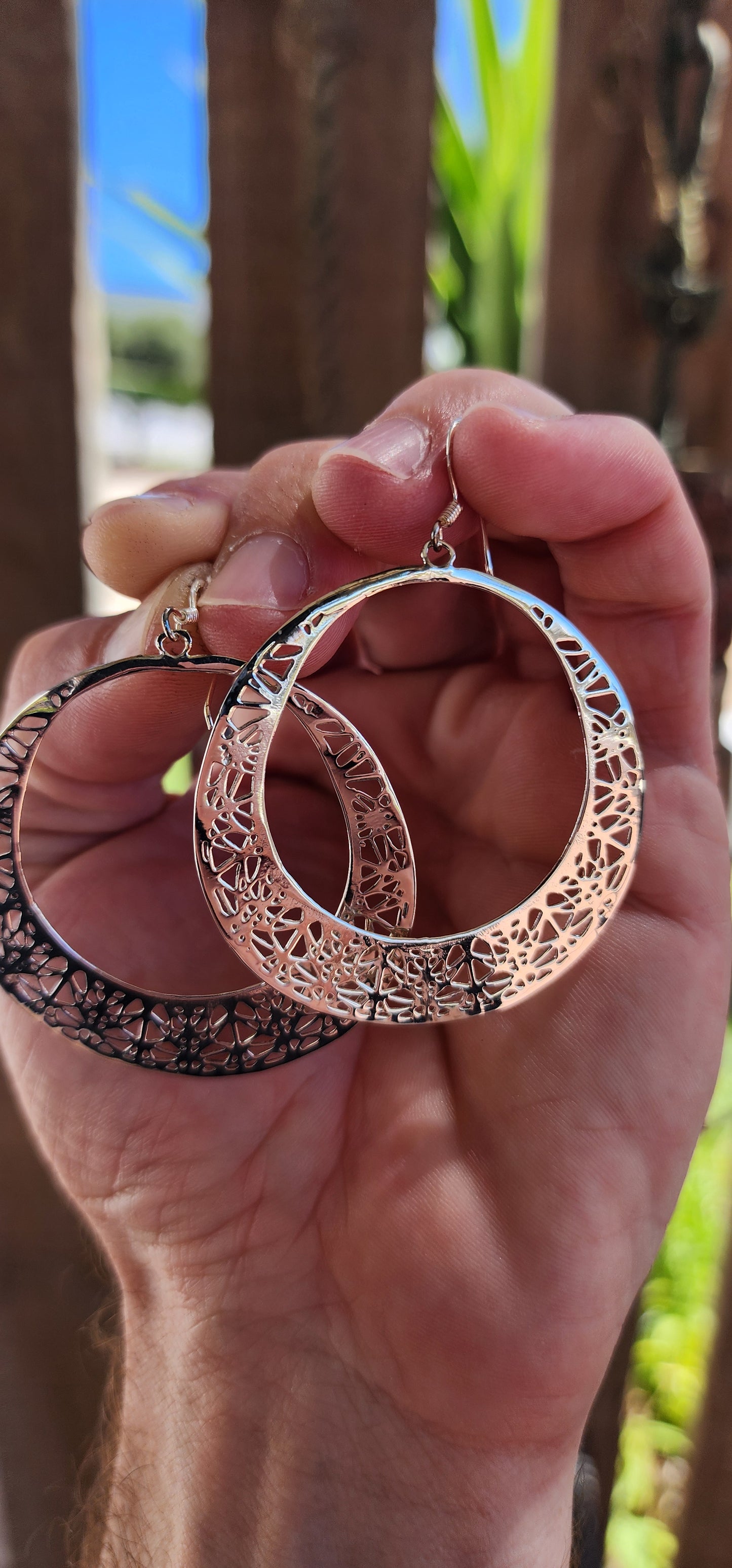 These oversized sterling silver hoop dangle earrings are an exquisite example of fine craftsmanship, blending timeless elegance with a touch of intricate artistry.