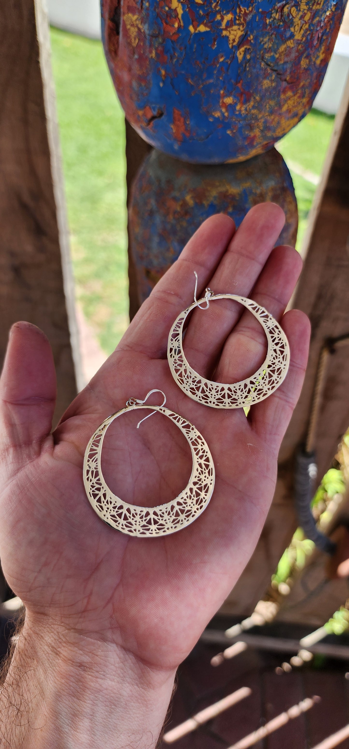 These oversized sterling silver hoop dangle earrings are an exquisite example of fine craftsmanship, blending timeless elegance with a touch of intricate artistry.