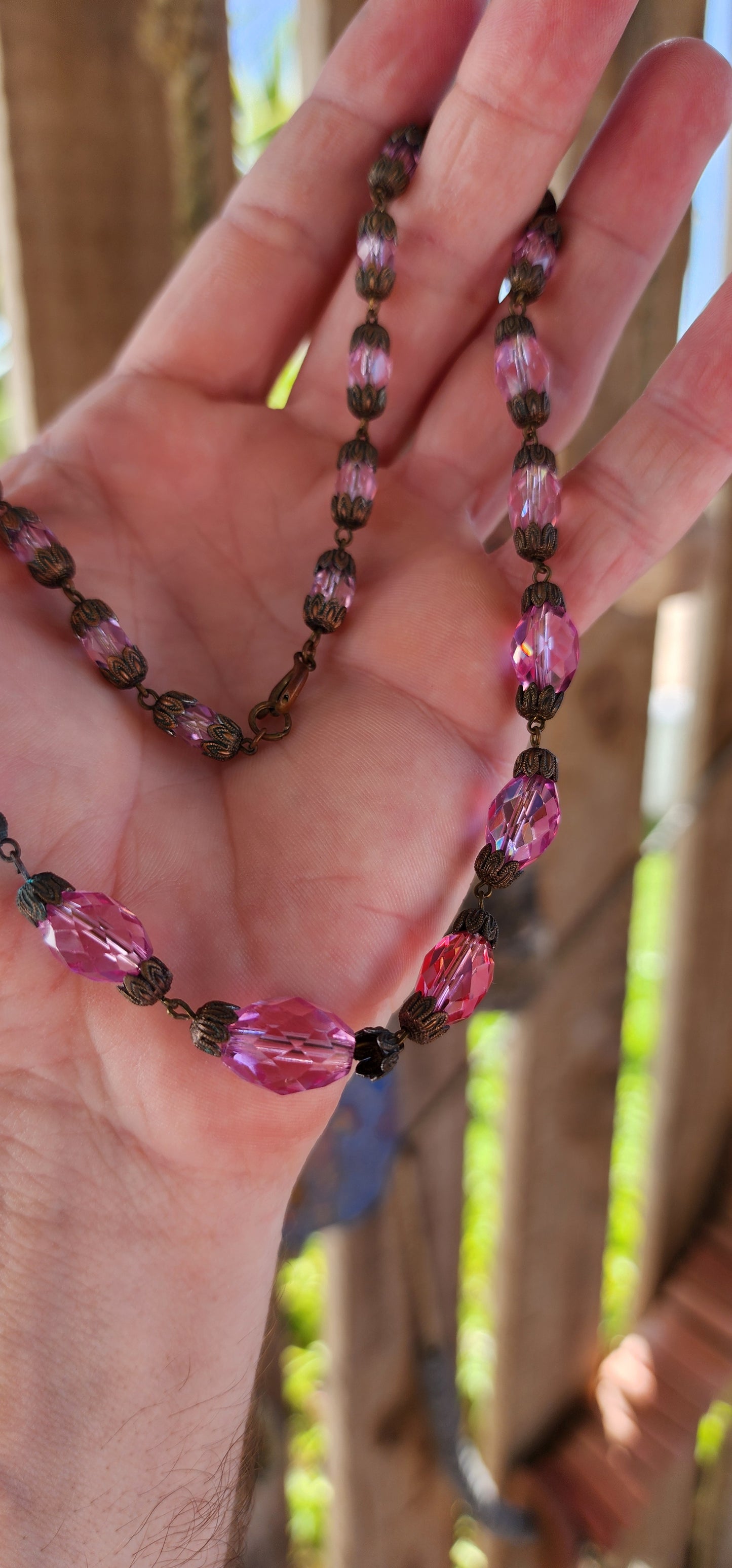 This exquisite antique 1920s Pink Czech crystal necklace is a delicate symphony of light and color, masterfully crafted with graduated faceted pink crystal beads that shimmer with every movement.