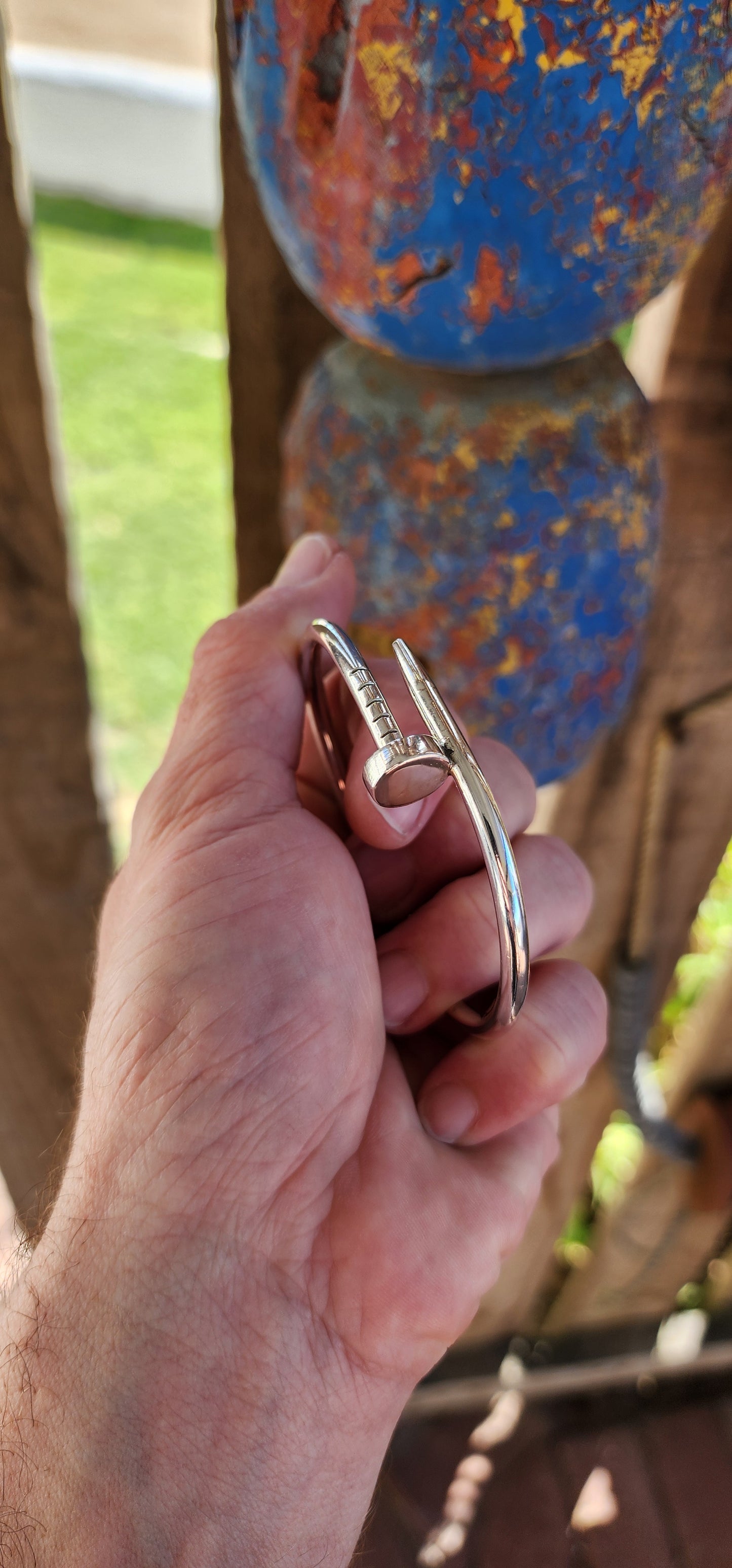 This solid sterling silver nail clip-bangle is a bold, industrial-chic statement piece that fuses rugged edge with high fashion elegance.