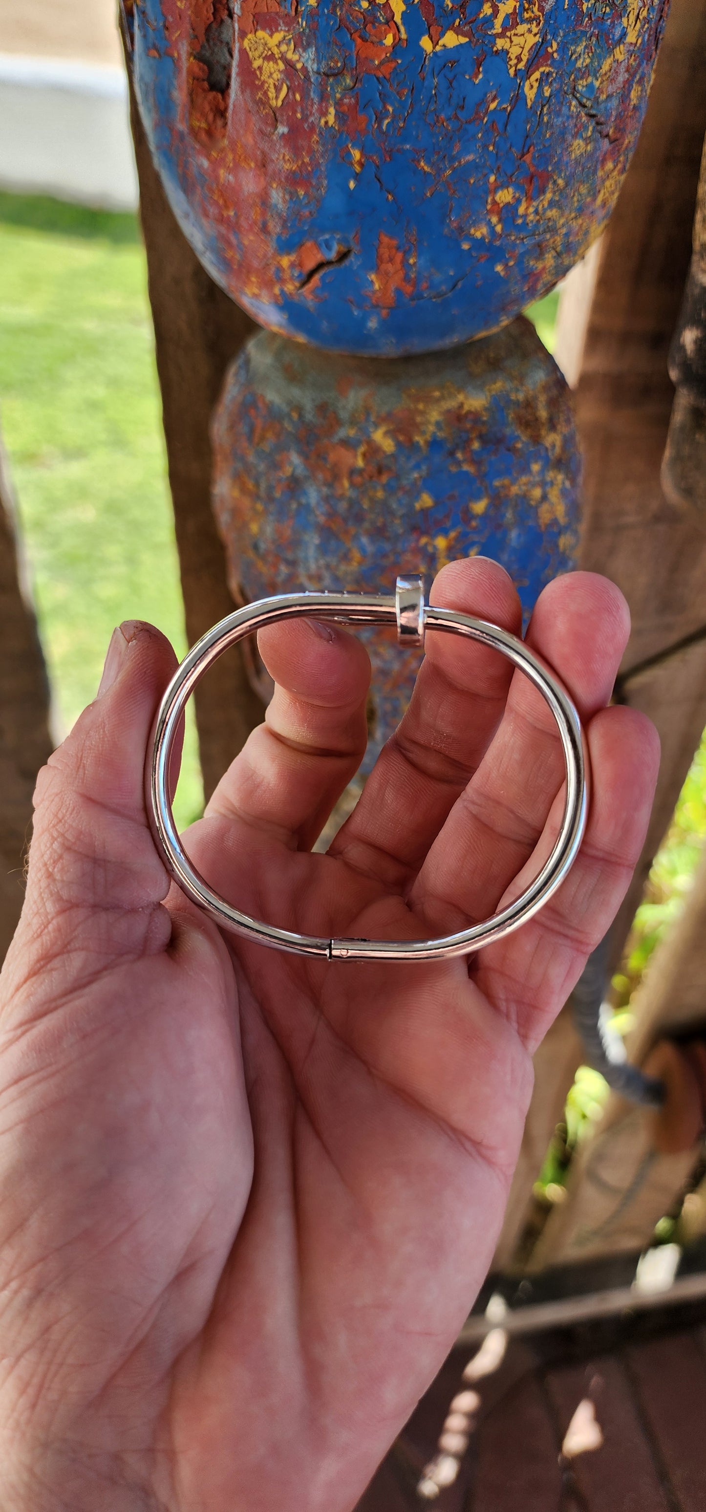 This solid sterling silver nail clip-bangle is a bold, industrial-chic statement piece that fuses rugged edge with high fashion elegance.