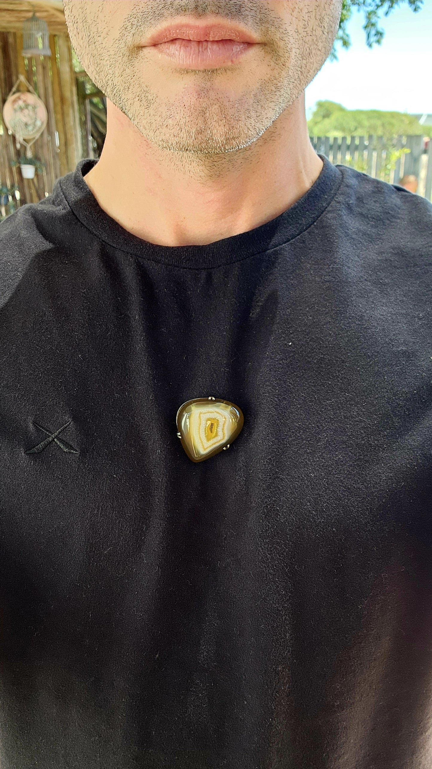 This marvelous vintage mid-century brooch is a stunning fusion of nature’s artistry and classic silver craftsmanship. Featuring a polished banded agate cabochon in its natural organic shape, this piece evokes the mesmerizing gaze of a dragon’s eye.