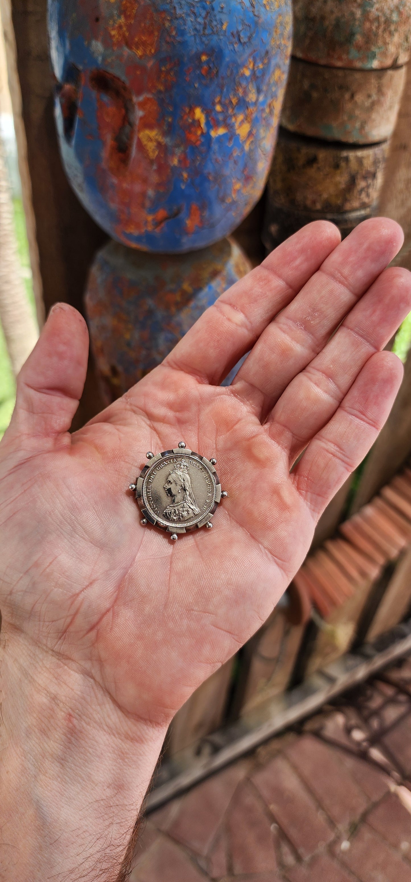 This exquisite antique Victorian-era brooch is crafted in sterling silver and features a 1887 Queen Victoria Jubilee Head silver shilling coin as its central element.