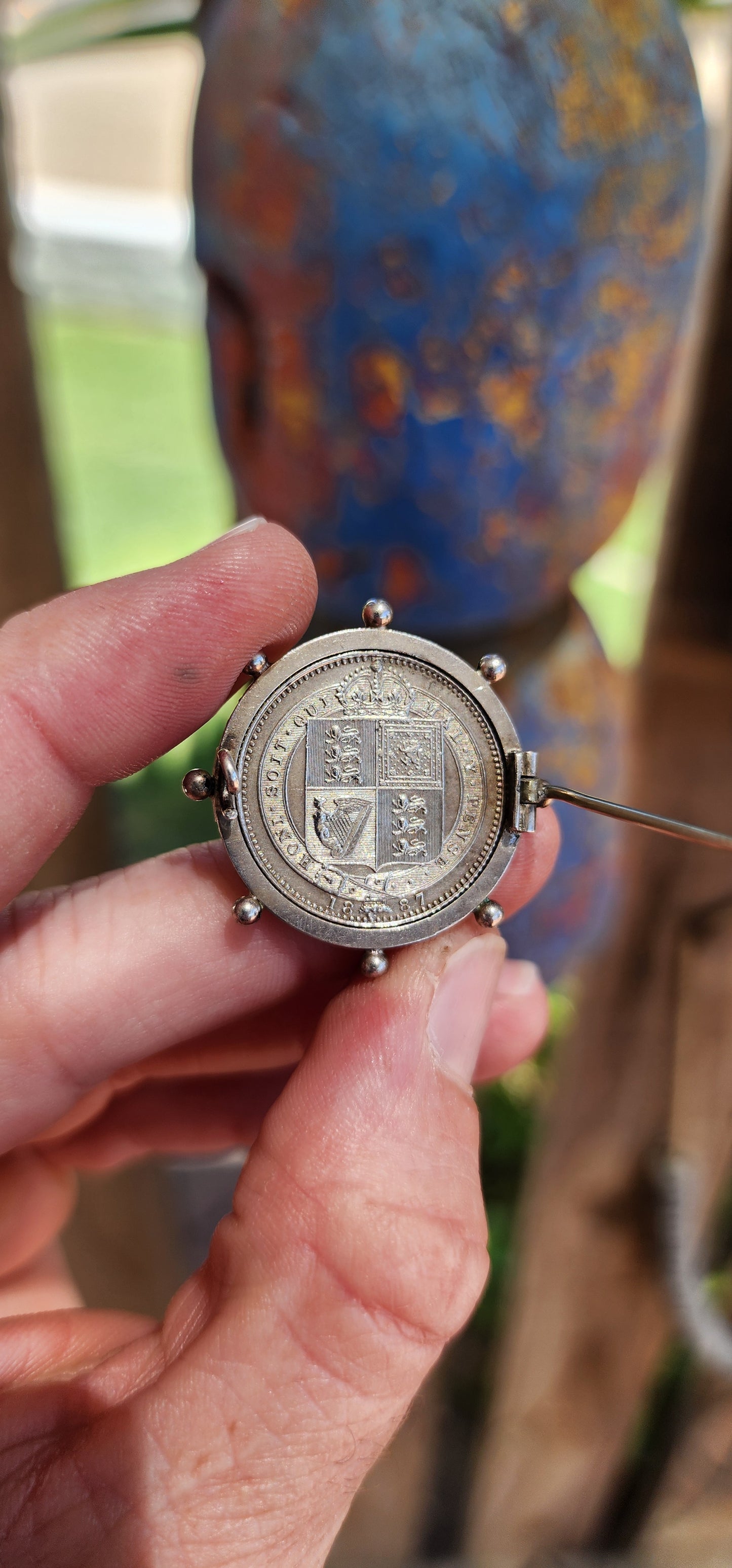 This exquisite antique Victorian-era brooch is crafted in sterling silver and features a 1887 Queen Victoria Jubilee Head silver shilling coin as its central element.