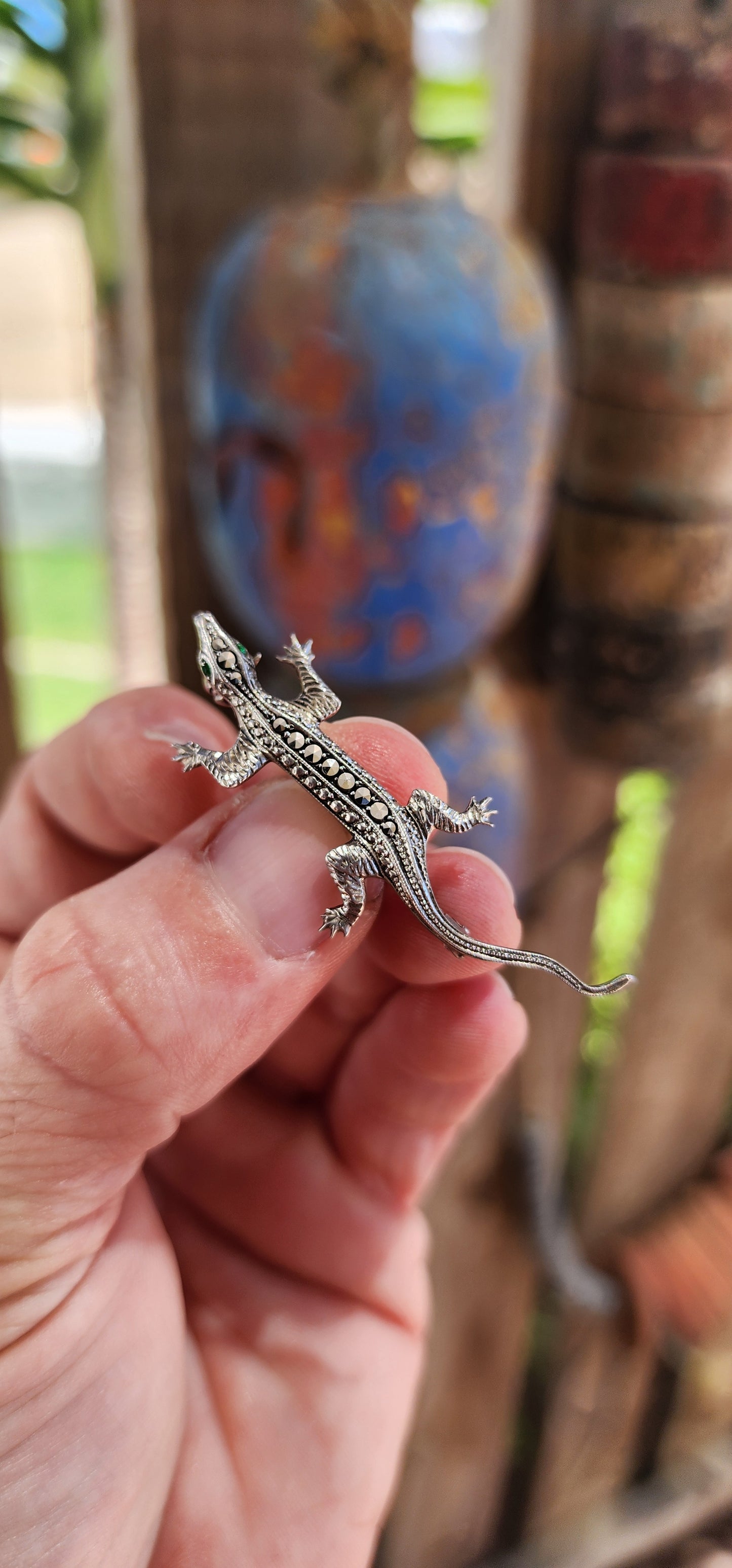 This stunning piece of wearable history is an Art Deco-era brooch from the 1930s, crafted in 800 silver and set with glittering marcasite gemstones and green emerald paste rhinestones. Its graceful, lifelike design takes the form of a lizard