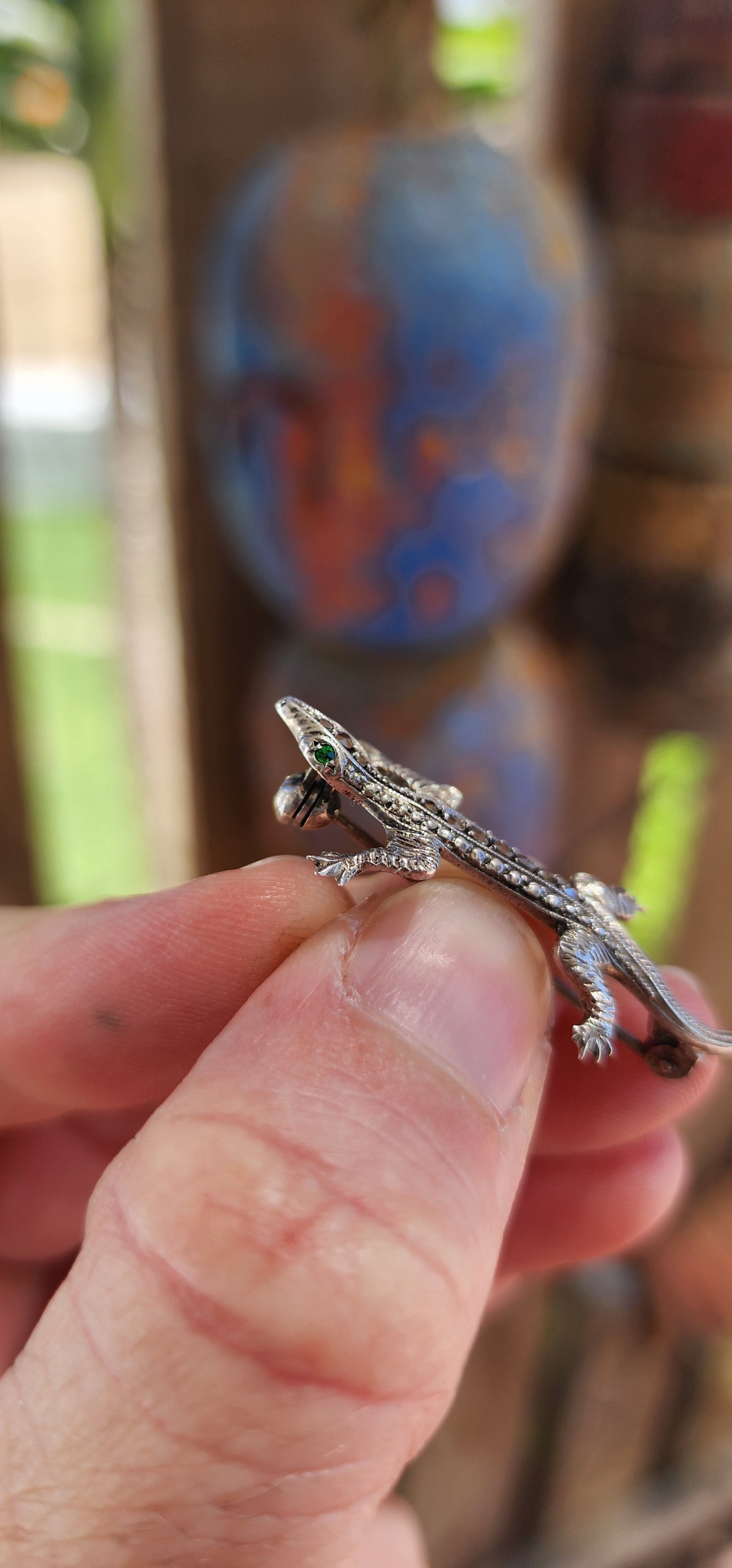This stunning piece of wearable history is an Art Deco-era brooch from the 1930s, crafted in 800 silver and set with glittering marcasite gemstones and green emerald paste rhinestones. Its graceful, lifelike design takes the form of a lizard