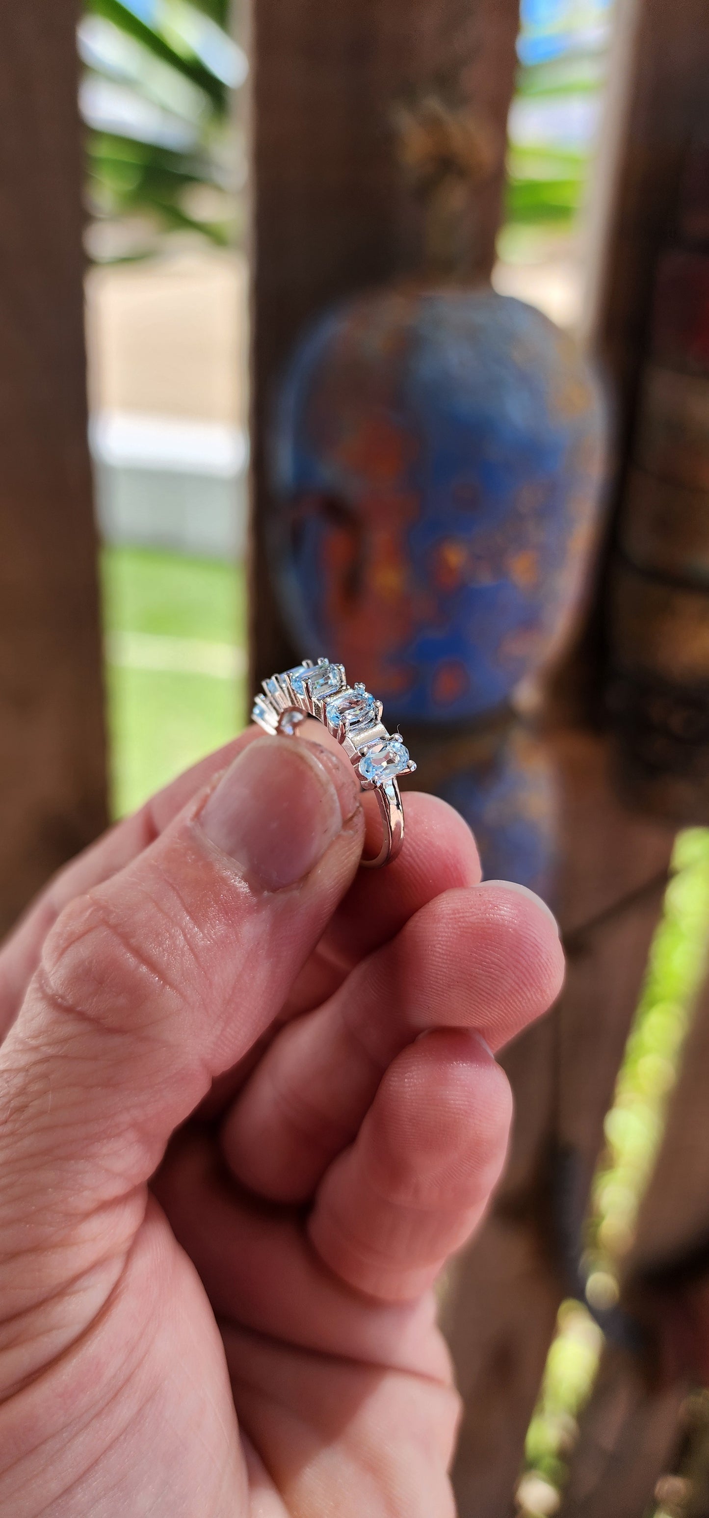 This sterling silver half-eternity ring is a refined and elegant piece, featuring five exquisite oval-cut sky blue topaz gemstones in a prong setting.