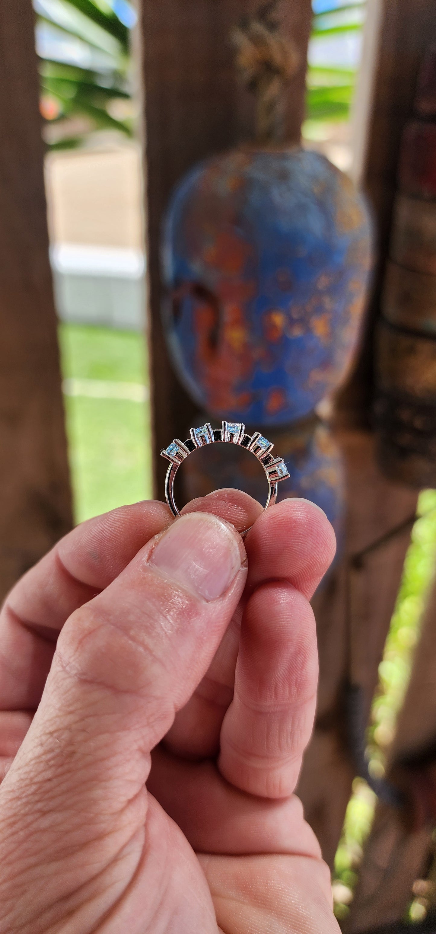 This sterling silver half-eternity ring is a refined and elegant piece, featuring five exquisite oval-cut sky blue topaz gemstones in a prong setting.