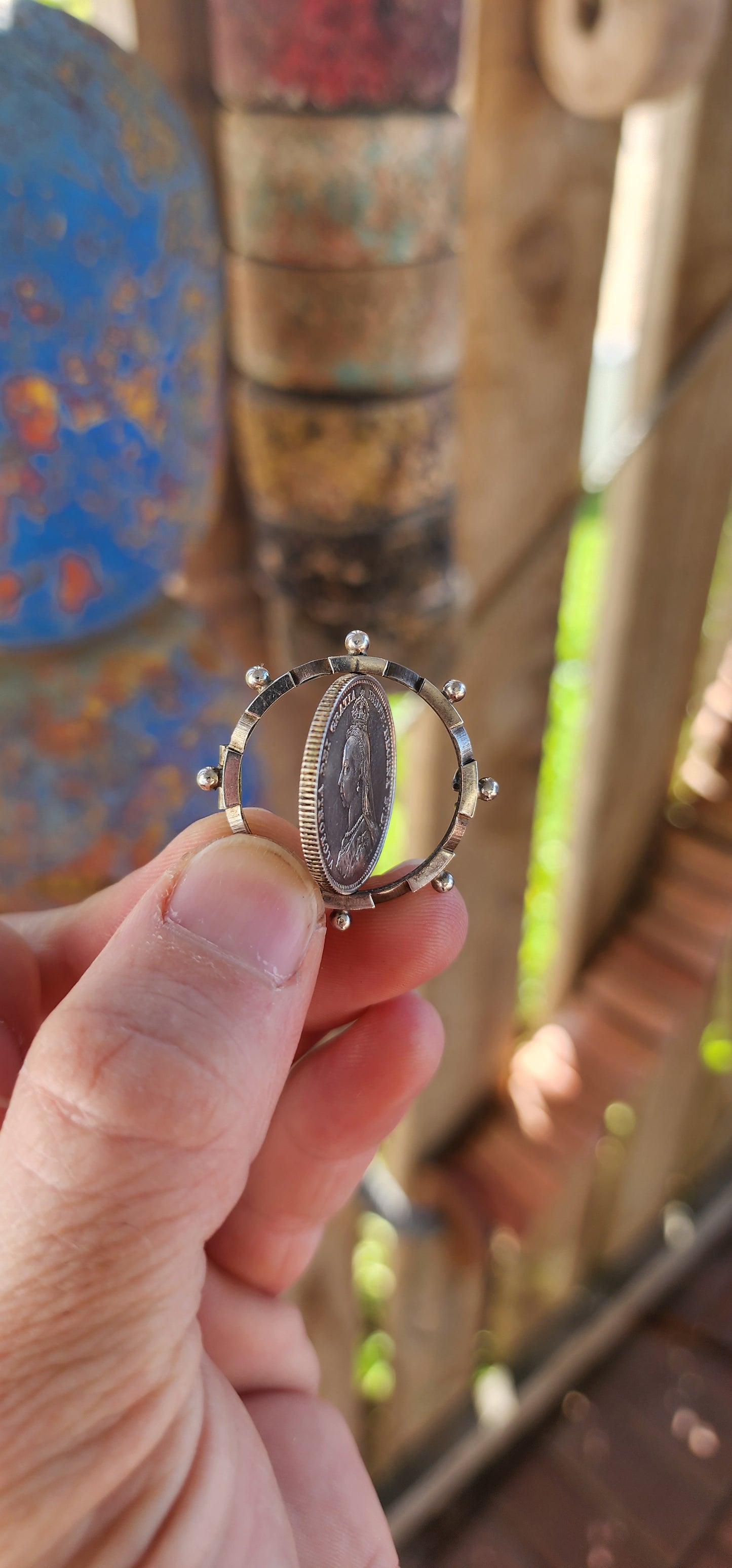 This exquisite antique Victorian-era brooch is crafted in sterling silver and features a 1887 Queen Victoria Jubilee Head silver shilling coin as its central element.